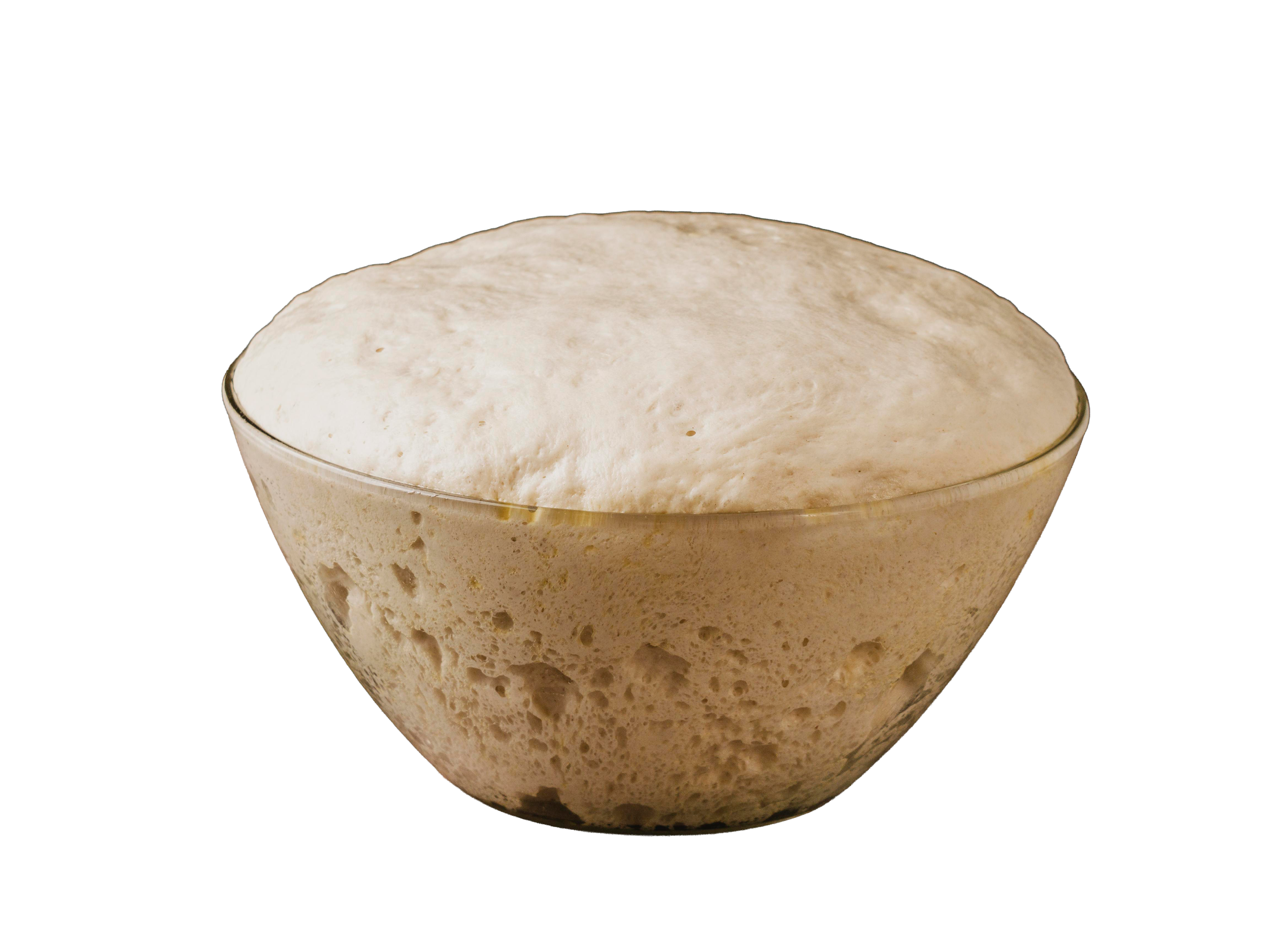 A glass bowl filled with freshly prepared, fluffy, risen bread dough.