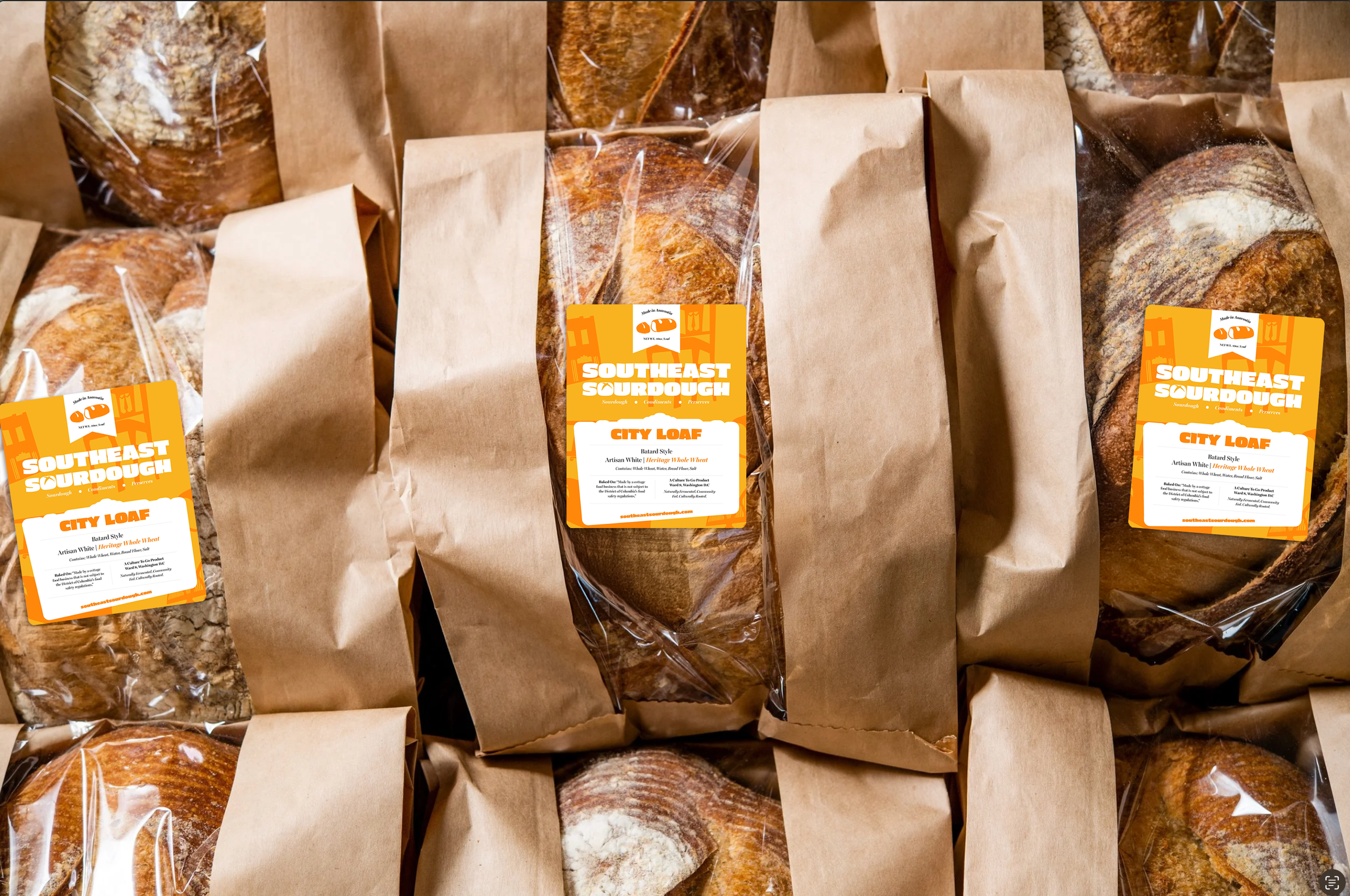 Several packages of sourdough bread labeled 'Southeast Sourdough City Loaf' wrapped in brown paper with labels, arranged closely together.