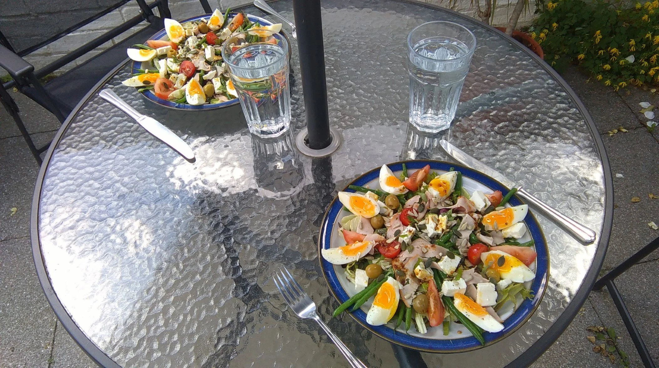 Mediterranean-style summer salad served outdoors with two glasses of water