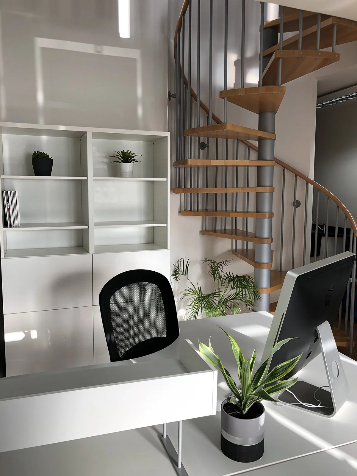 Clean and tidy desk in a work space with spiral staircase
