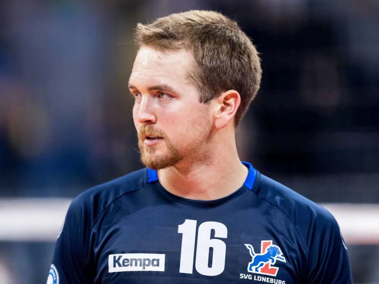 Joe Worseley wearing a navy blue sports jersey, number 16, with a lion logo and the text "SVG Lüneburg". The background is blurred.
