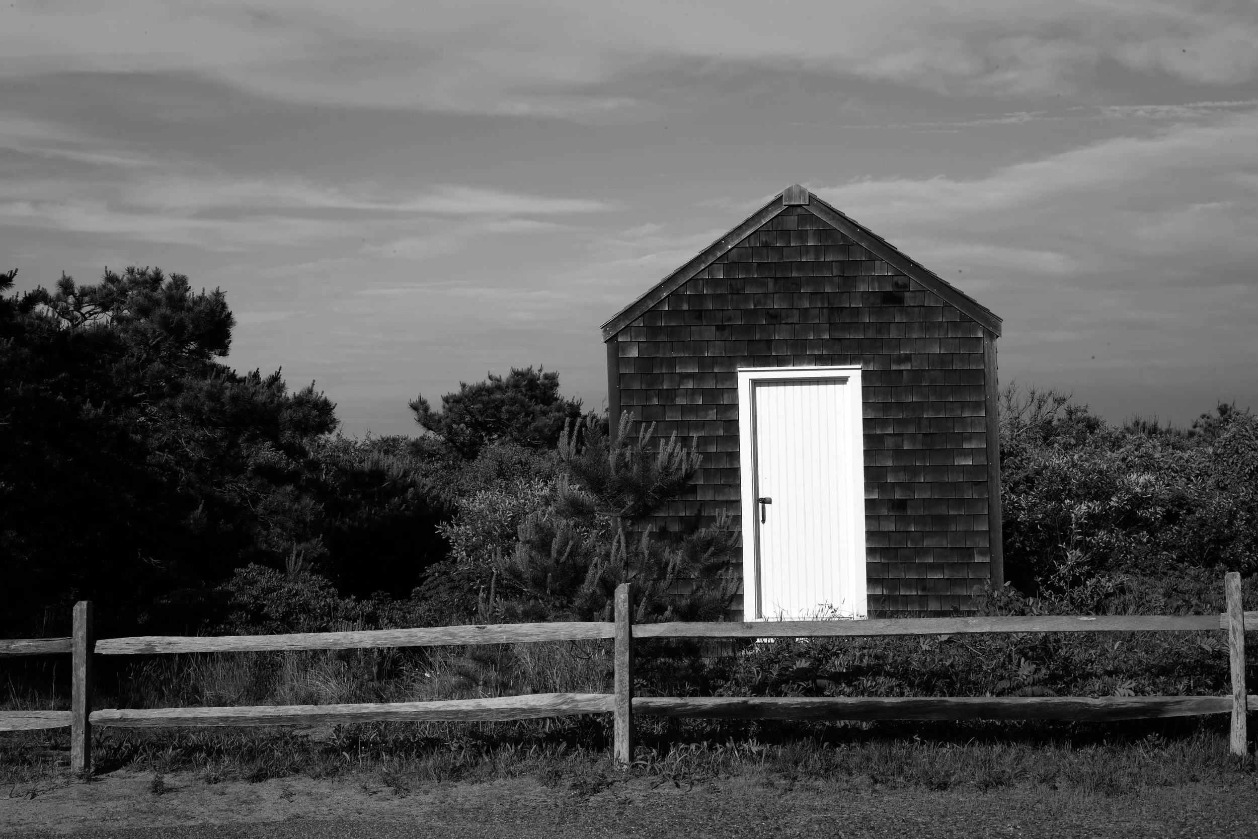 Black and white photograph of a cabin in the sand dunes out on the Outer Cape Cod