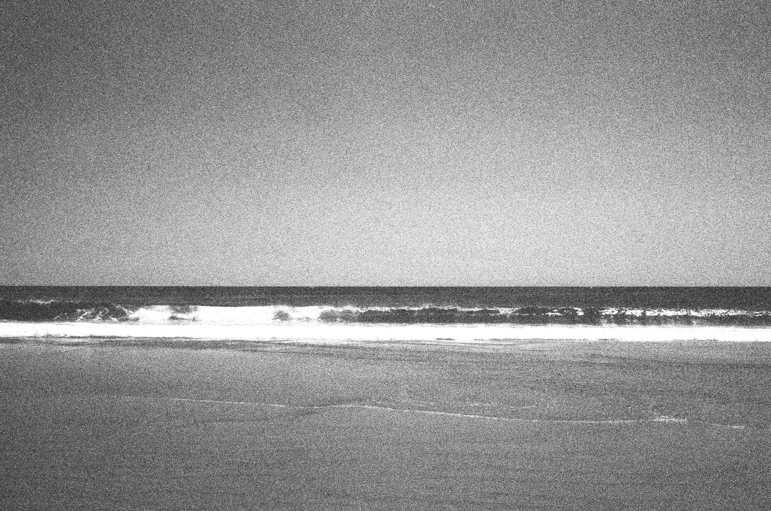 Black and White photograph of Nauset Beach with the waves crashing onto the sandy shore line