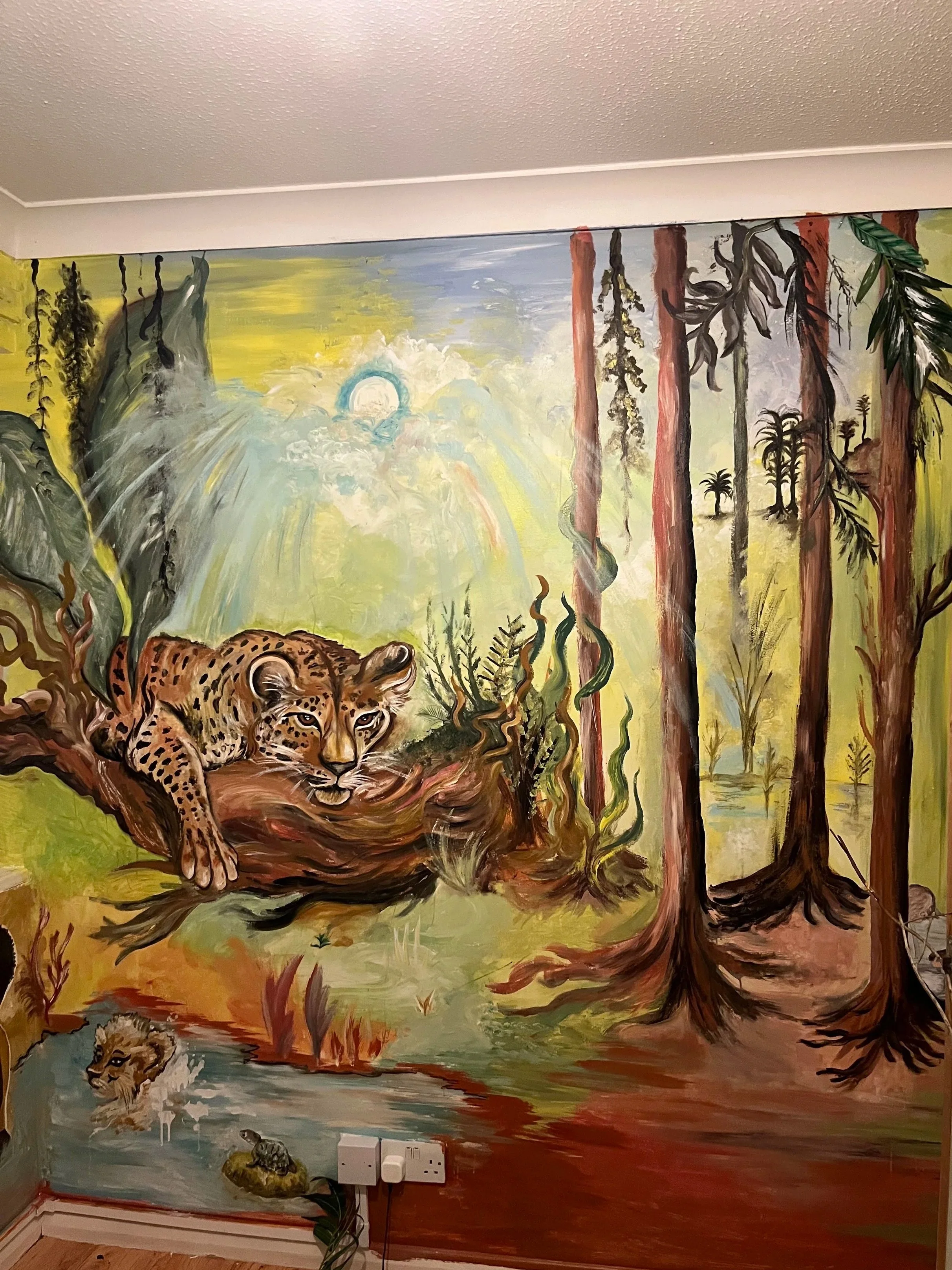 Colorful jungle scene mural featuring a leopard resting on a fallen tree branch, a lion cub swimming in water, and tall trees with lush foliage and a bright sky.