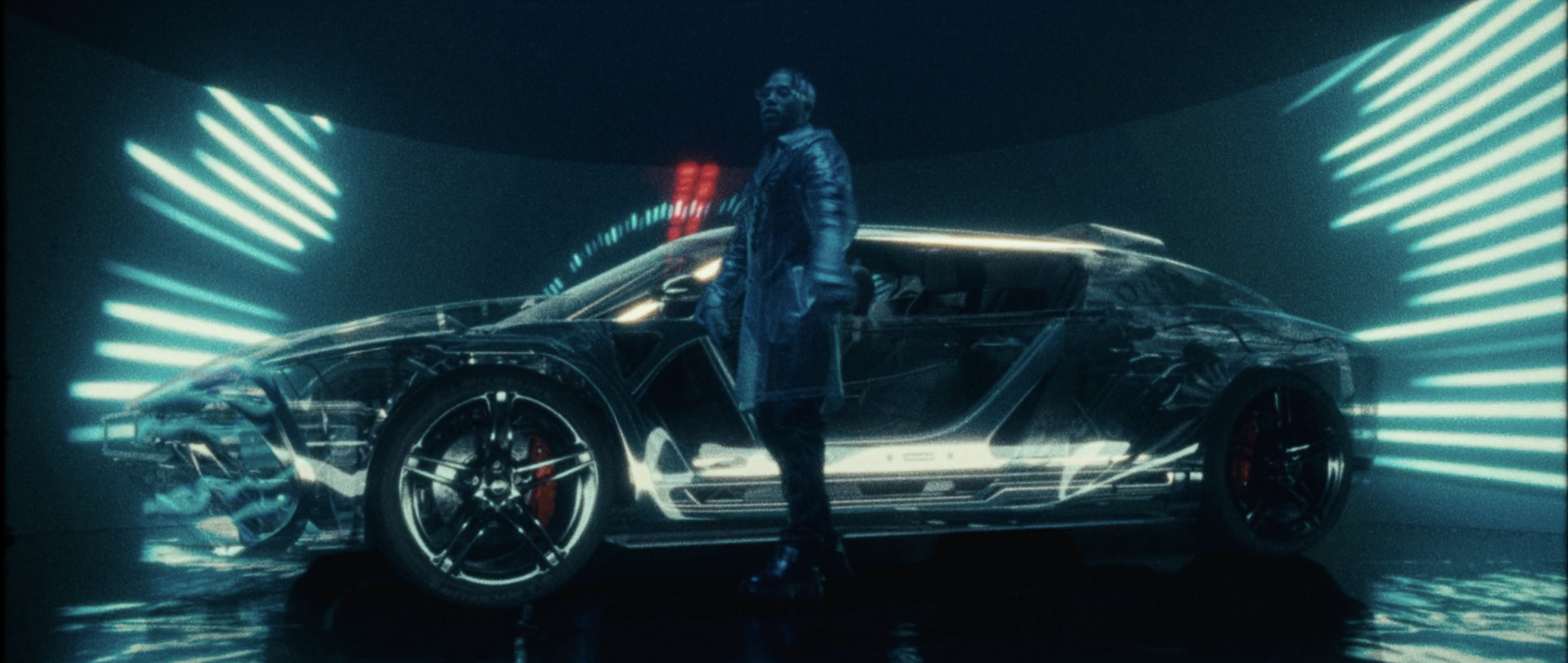 A man standing next to a futuristic, transparent sports car illuminated by neon blue lights in a dark room.