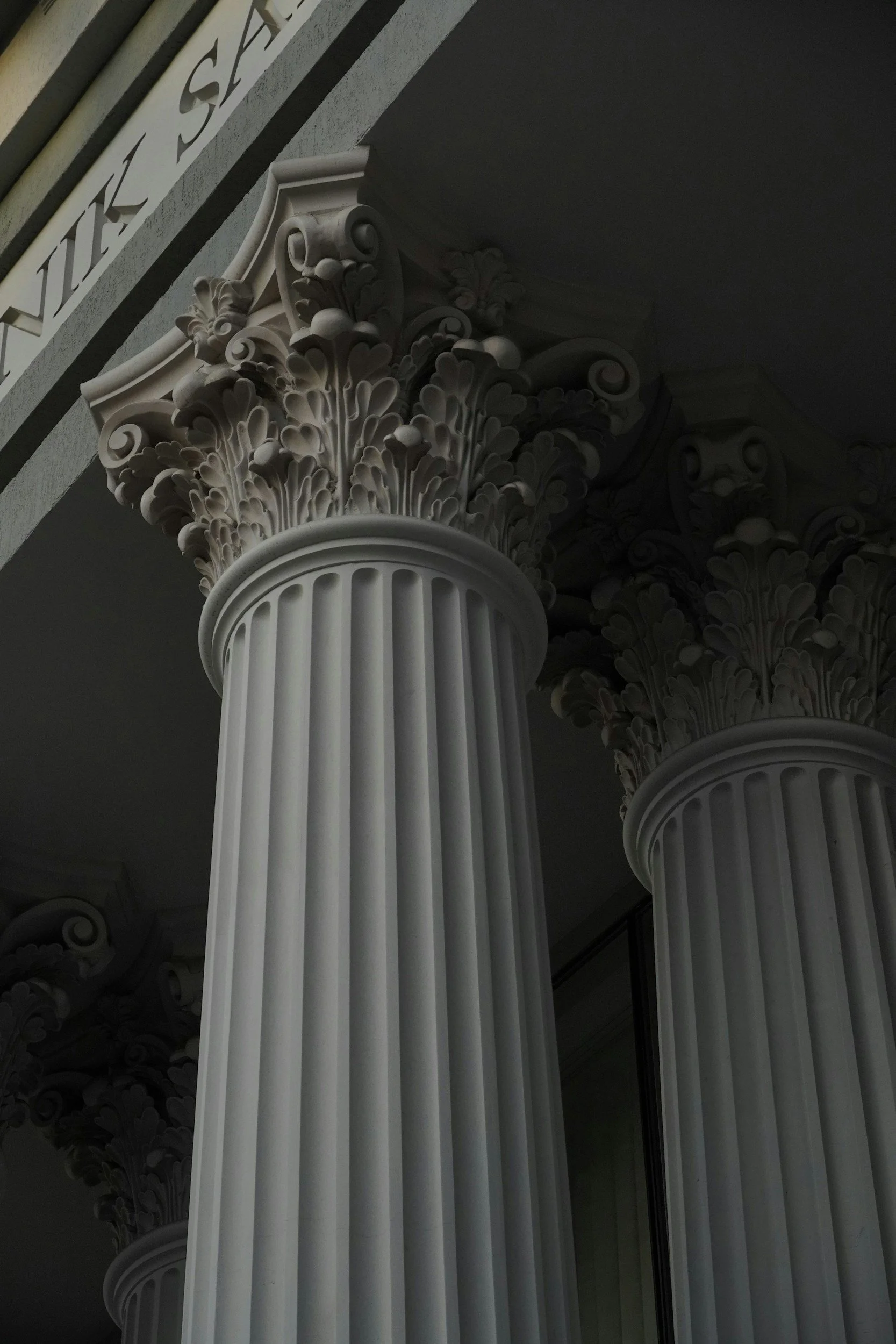 Close-up of classical columns with ornate acanthus leaf capitals.  EU regulatory policy and public affairs, political communications.