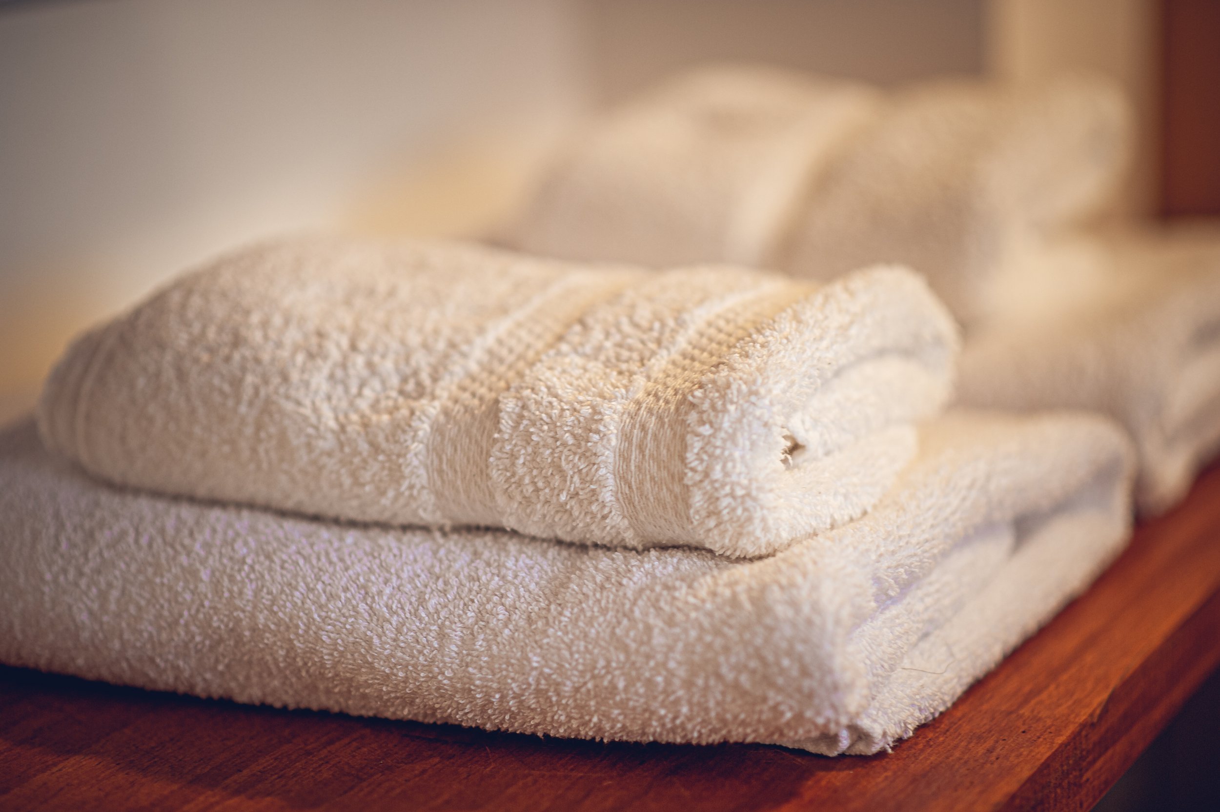 Toallas de baño apiladas en una superficie de madera.