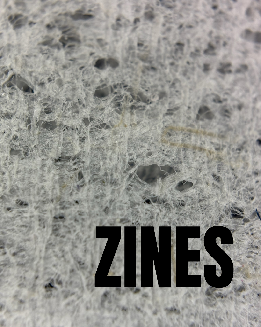 Textured gray background with black text: zine