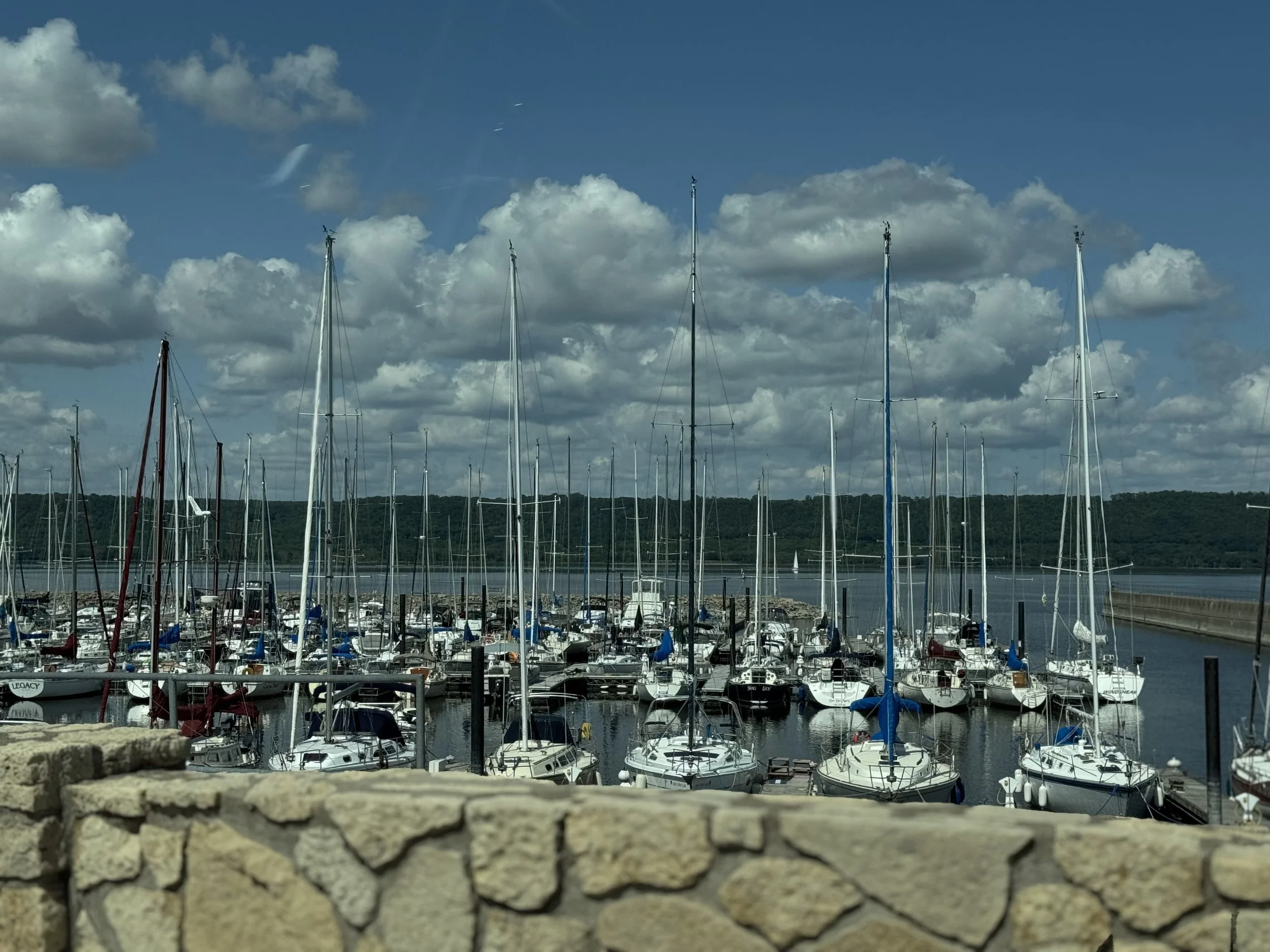 A partly cloudy day at a lake harbor storing about 100 fishing boats.