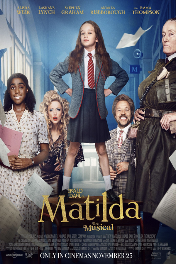 A poster for the musical "Matilda" featuring a girl standing confidently on a desk with hands on hips, surrounded by four adults with varied expressions, set in a classroom environment with blue walls and books.