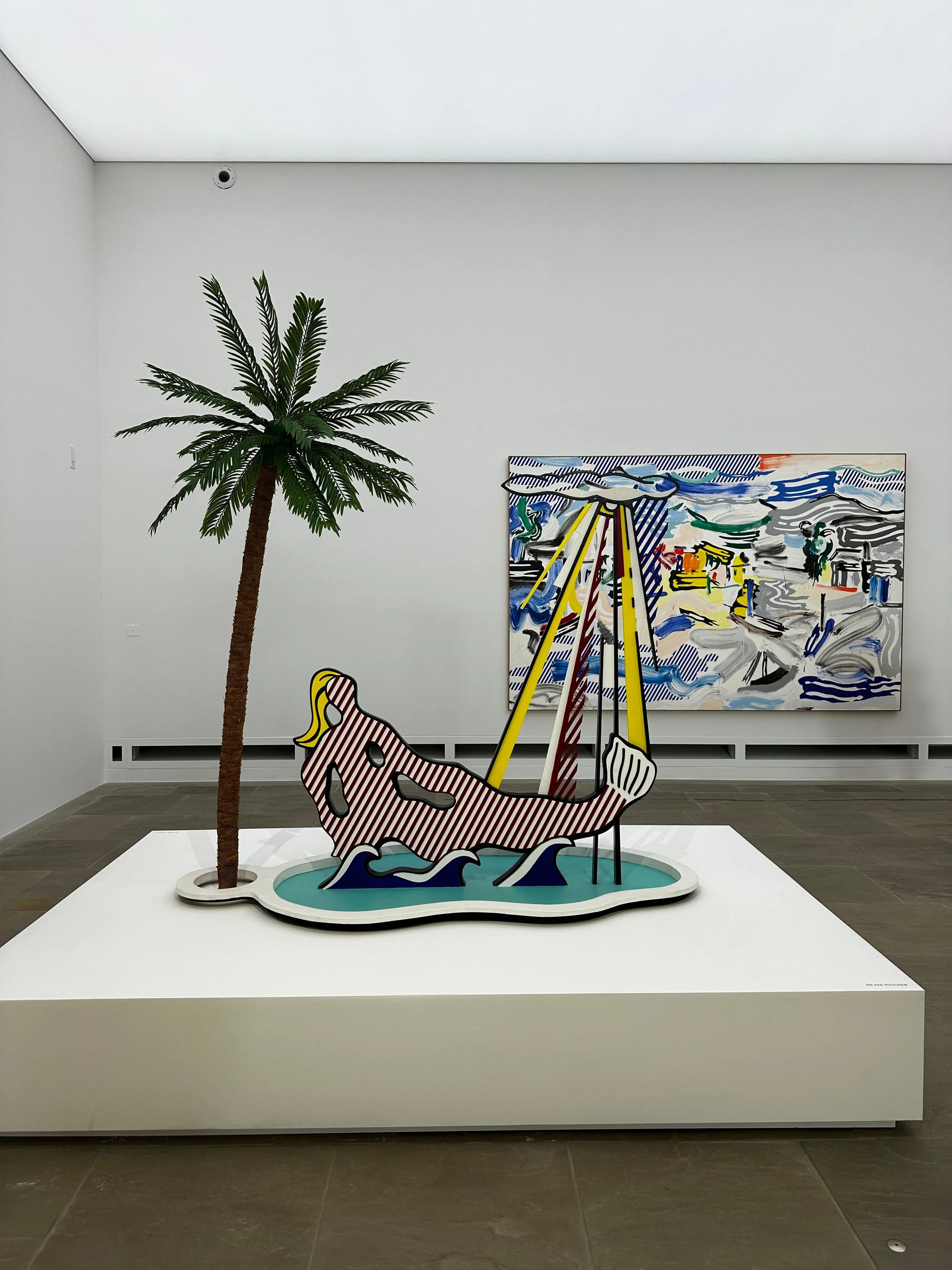 Roy Lichtenstein pop art sculpture of a reclining woman beneath a palm tree displayed at Fondation Villa Carmignac's Sea, Pop & Sun exhibition on Porquerolles.