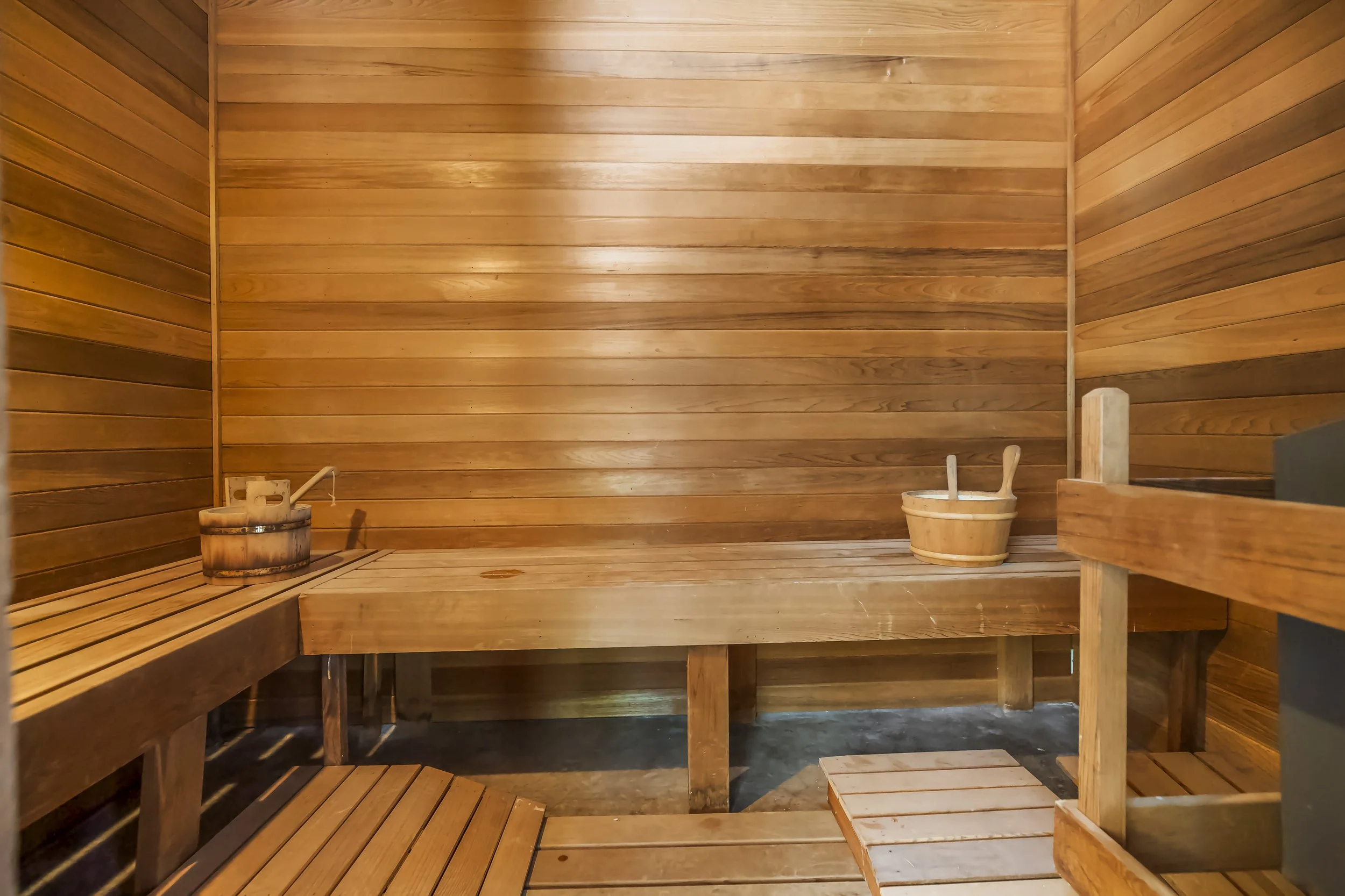 Inside a traditional wooden sauna with wooden benches and buckets.