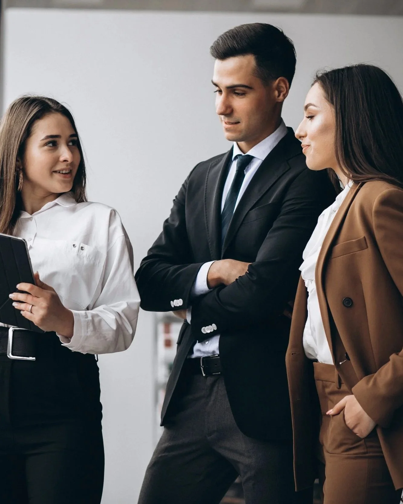 Três pessoas de negócios conversando em um ambiente de escritório.