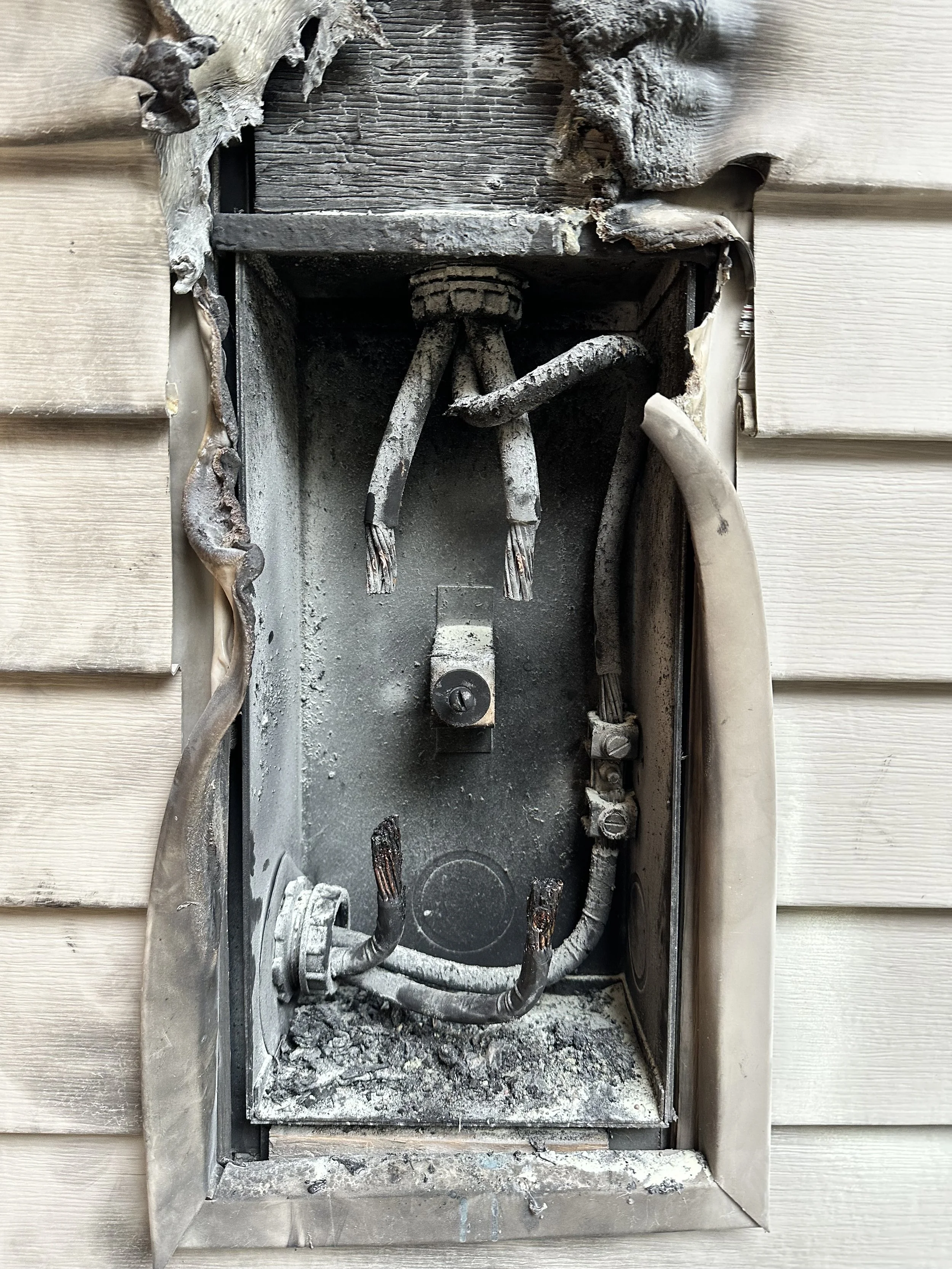Electrical fire damage at meter and main panel outside home in North Idaho