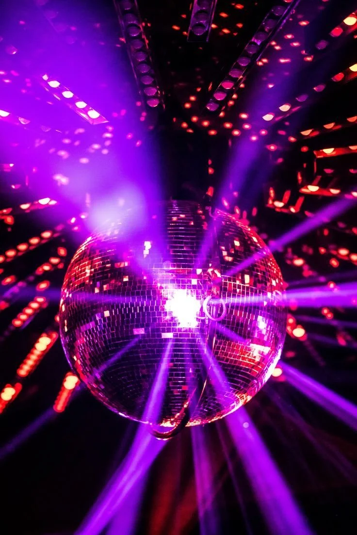 A disco ball reflecting colorful lights during a dance party.