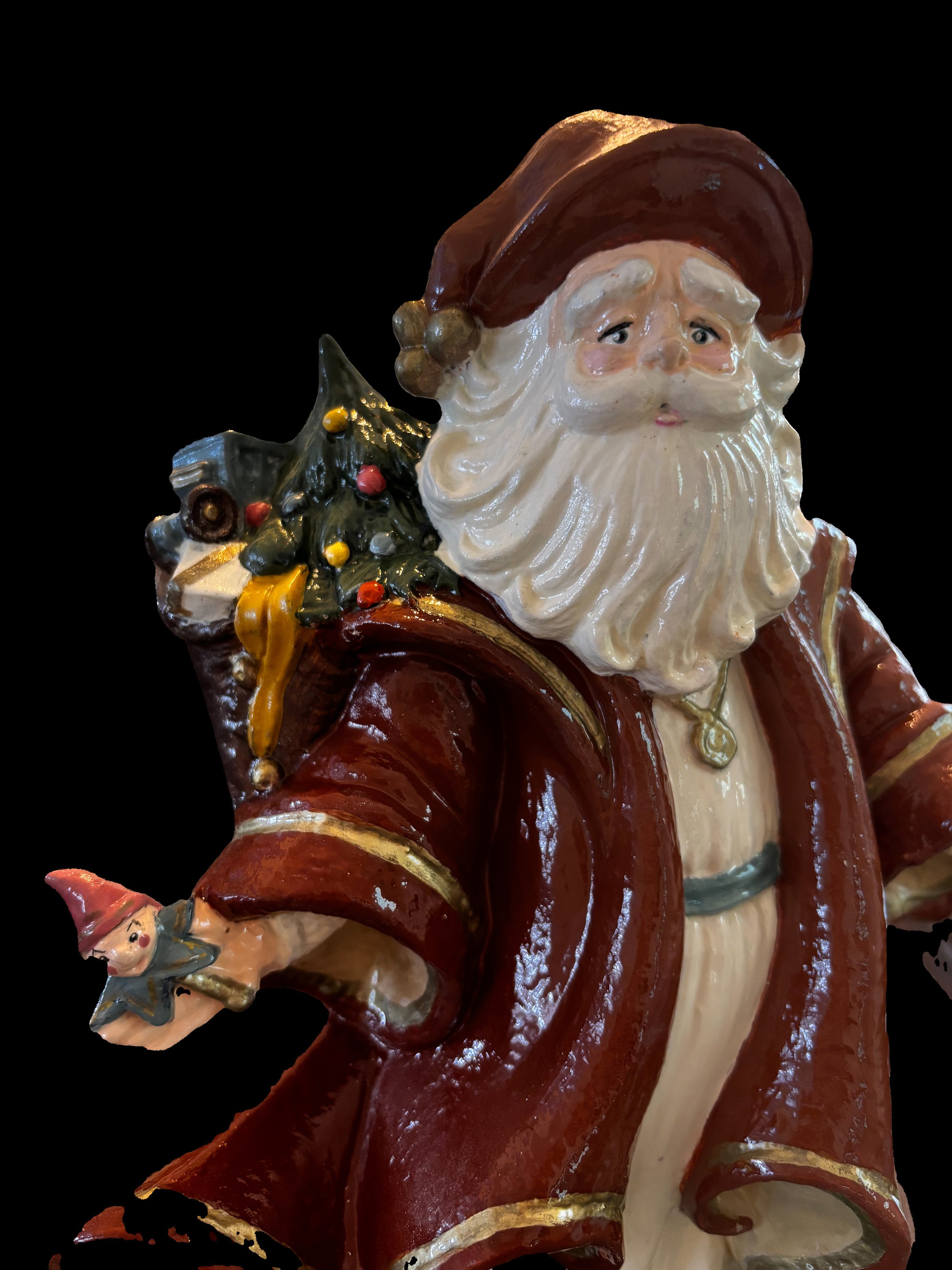 Decorative ceramic Santa Claus figure holding a Christmas tree with colorful ornaments, wearing a red and white outfit, set against a black background.