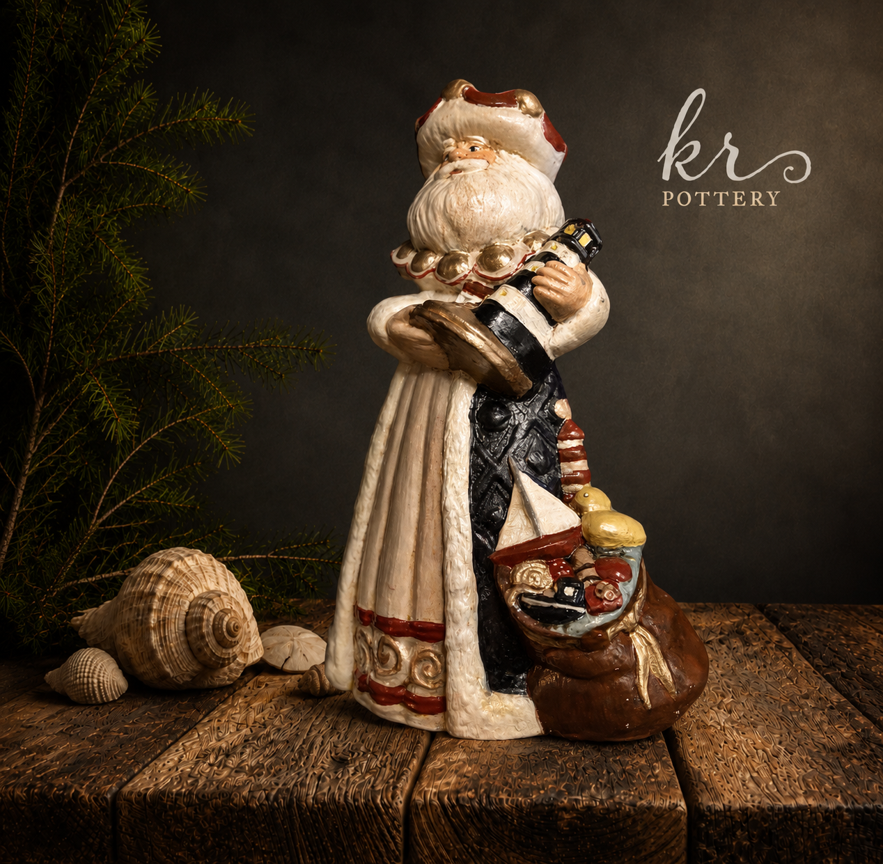 A ceramic Santa Claus figurine holding a bottle of champagne, standing on a wooden surface surrounded by seashells and a green pine branch, with a dark background and the words "KR Pottery" in the top right corner.