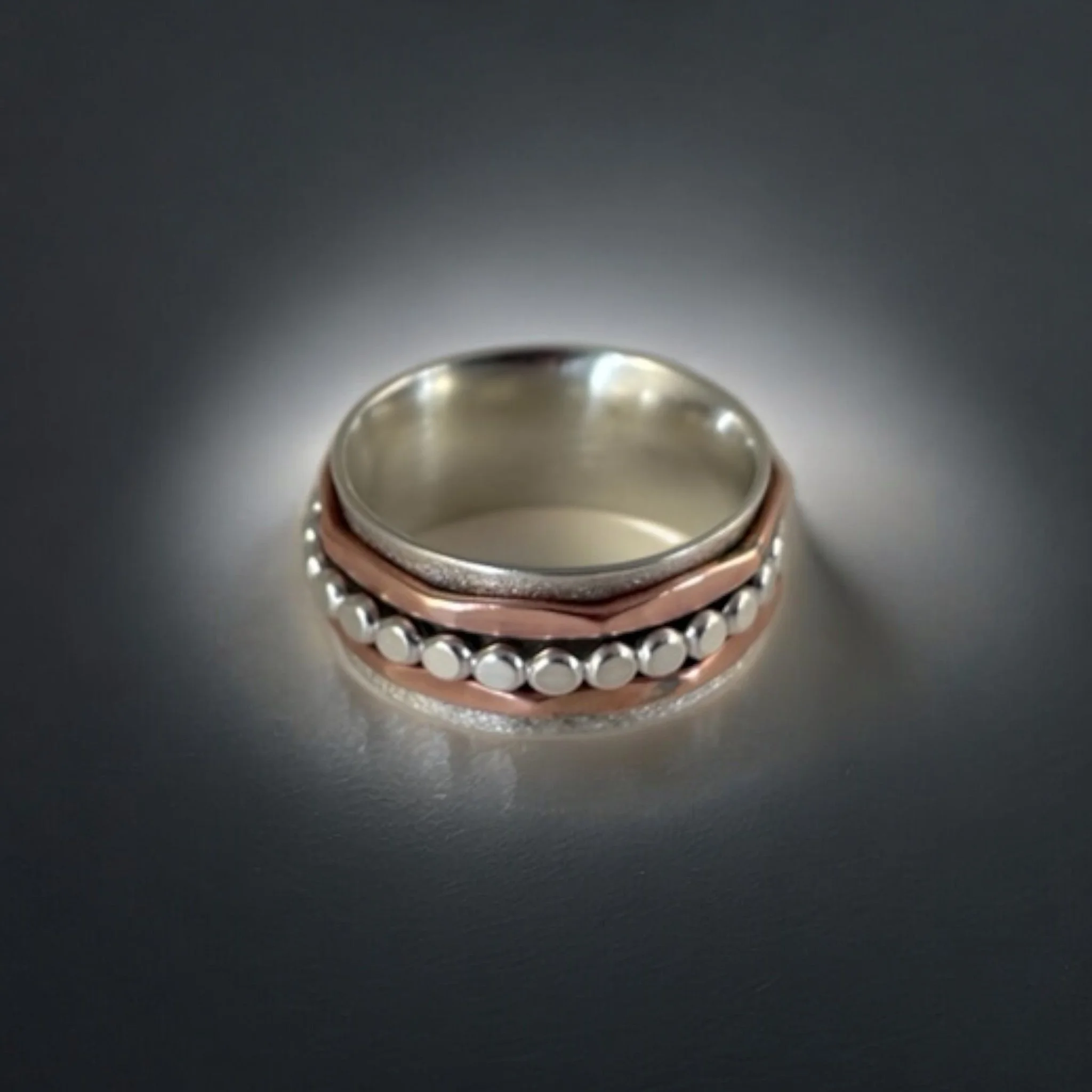 Sterling silver ring with a central copper accent and silver beaded detail.