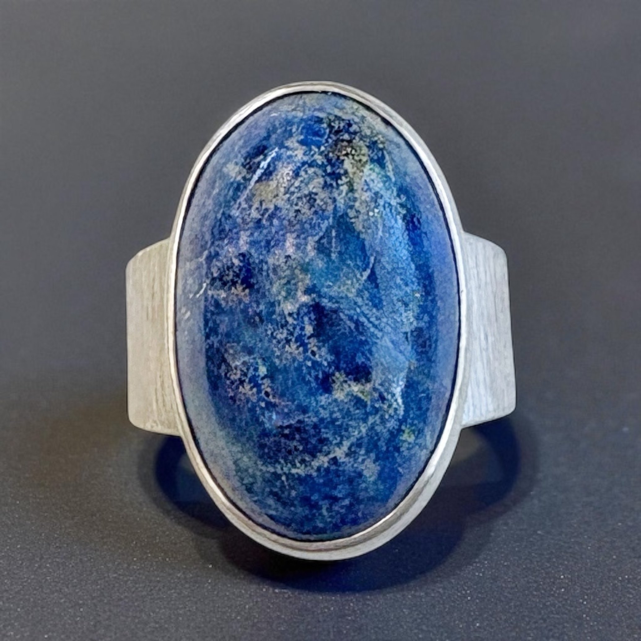 Lapis lazuli in a sterling silver ring with a textured wide band.