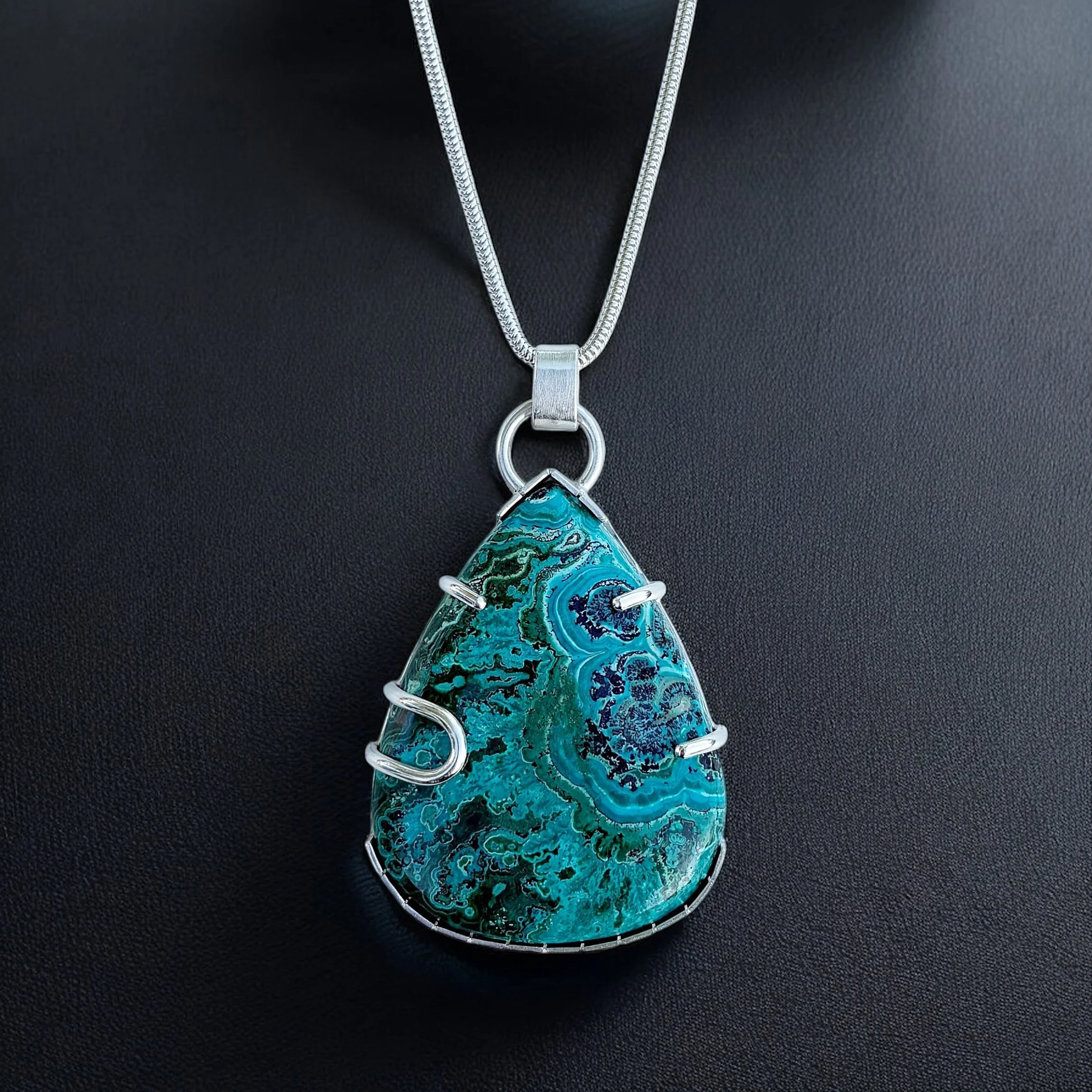 Chrysocolla malachite set in sterling silver with prong details.