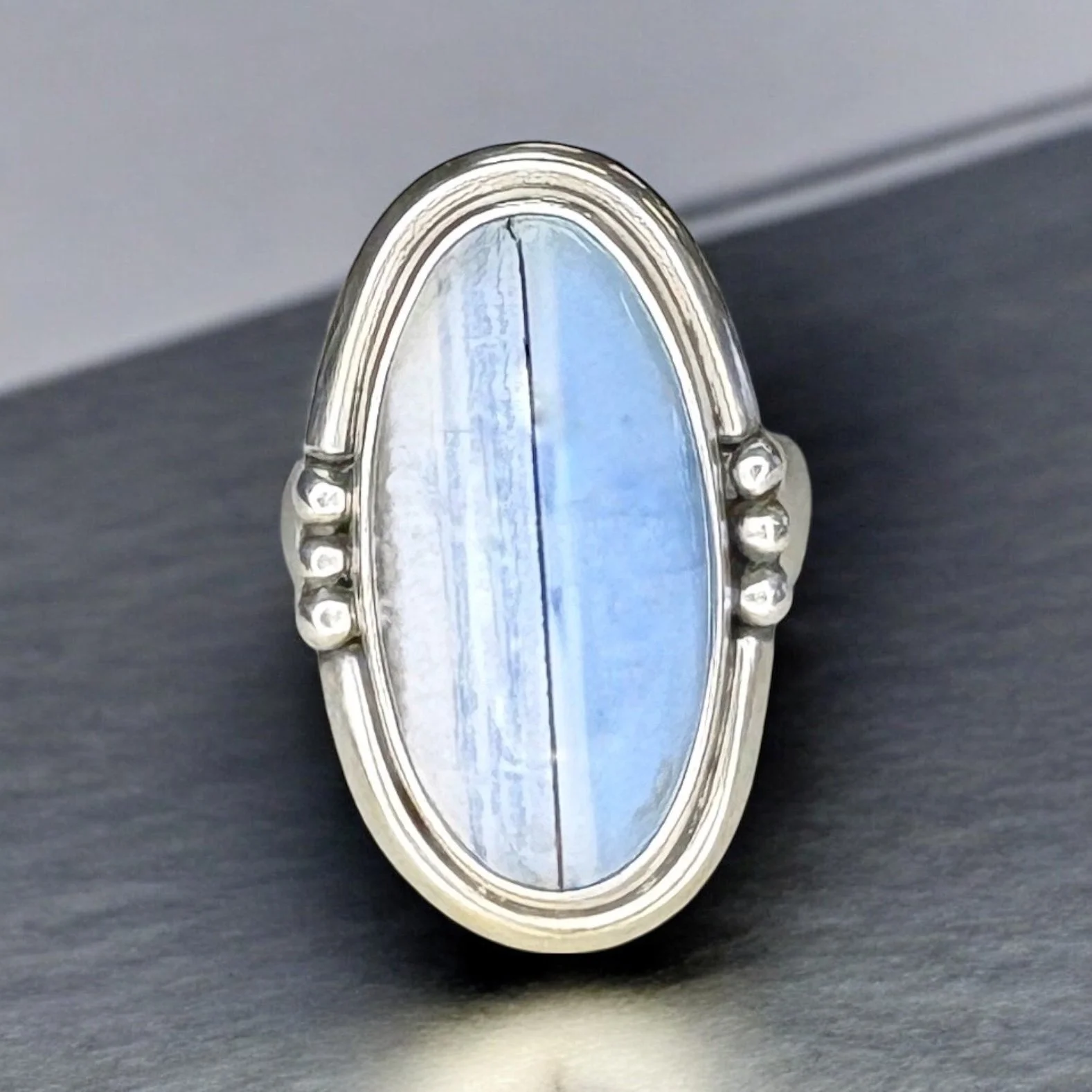 Blue Owyhee opal in a sterling silver ring with beaded side details.