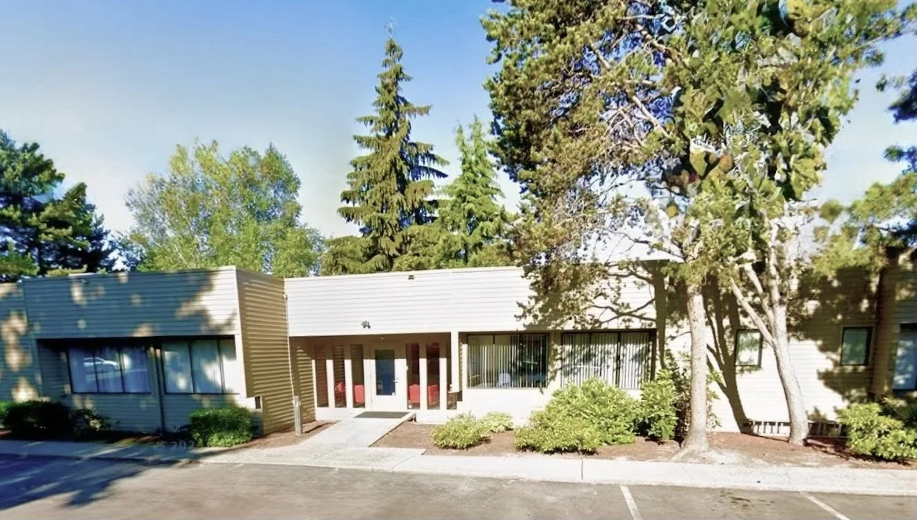 Exterior view of 608 State Street, Suite 130, Kirkland, WA office building, location of Eastside Christian Counseling with trees and shrubs in front, parking lot in the foreground.