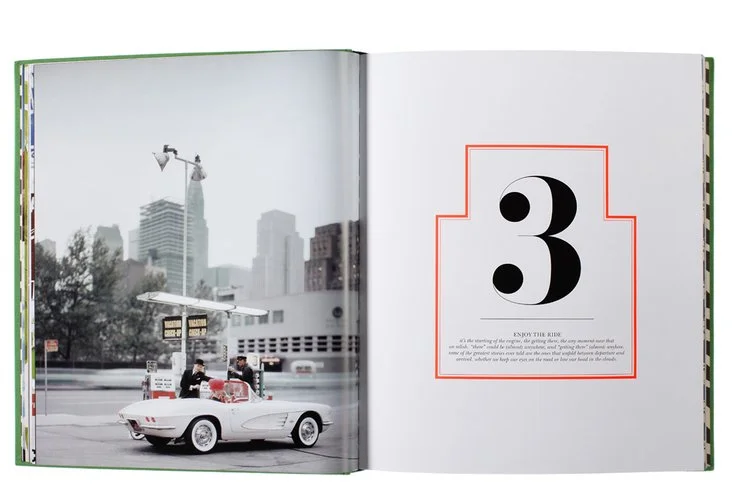 Open book showing a photo of a classic white convertible car with two people inside parked on a city street, with a cityscape and skyscrapers in the background. The right page has a large number 3 inside a red border.
