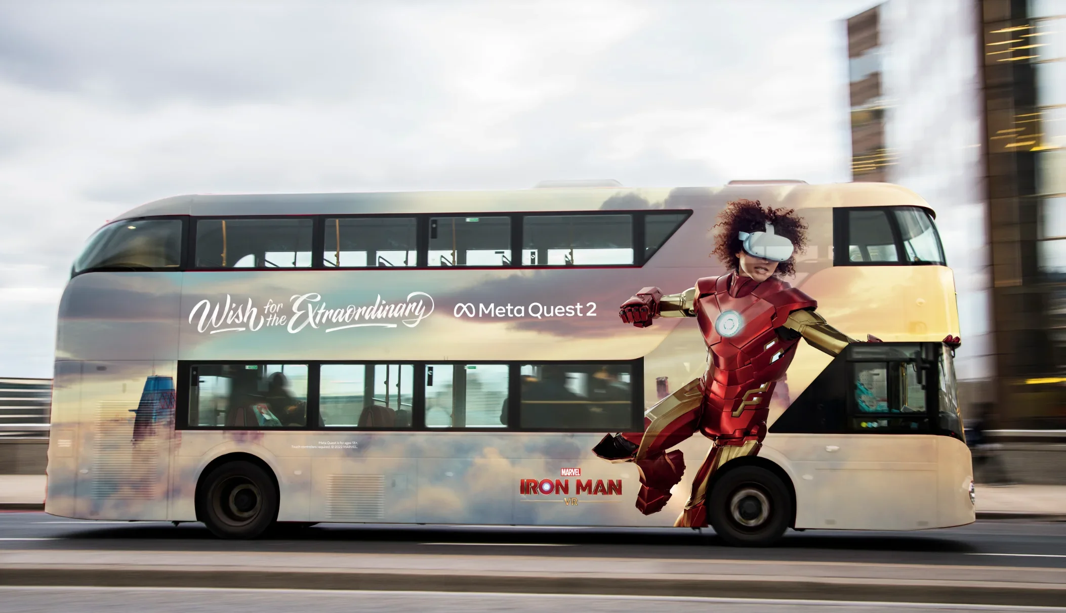 Double-decker bus with Marvel's Iron Man character and promotional text for 'Wish for the Extraordinary' and 'Meta Quest 2' moving on a city street. Meta. Bus. OOH. Miranda Kendrick. Producer.