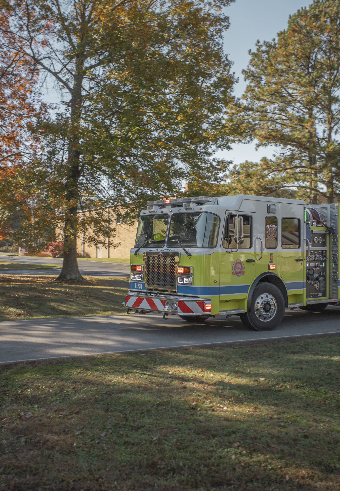 Fire truck on a street with trees in the background during daytime.