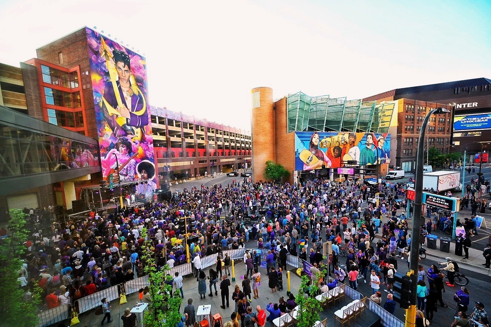 Outdoor festival crowd for Prince mural unveiling block party event demonstrating logistics, crowd coordination, and live entertainment production