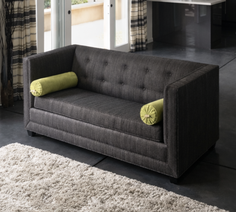 Custom upholstered sofa with tufted back and bolster pillows in San Diego home