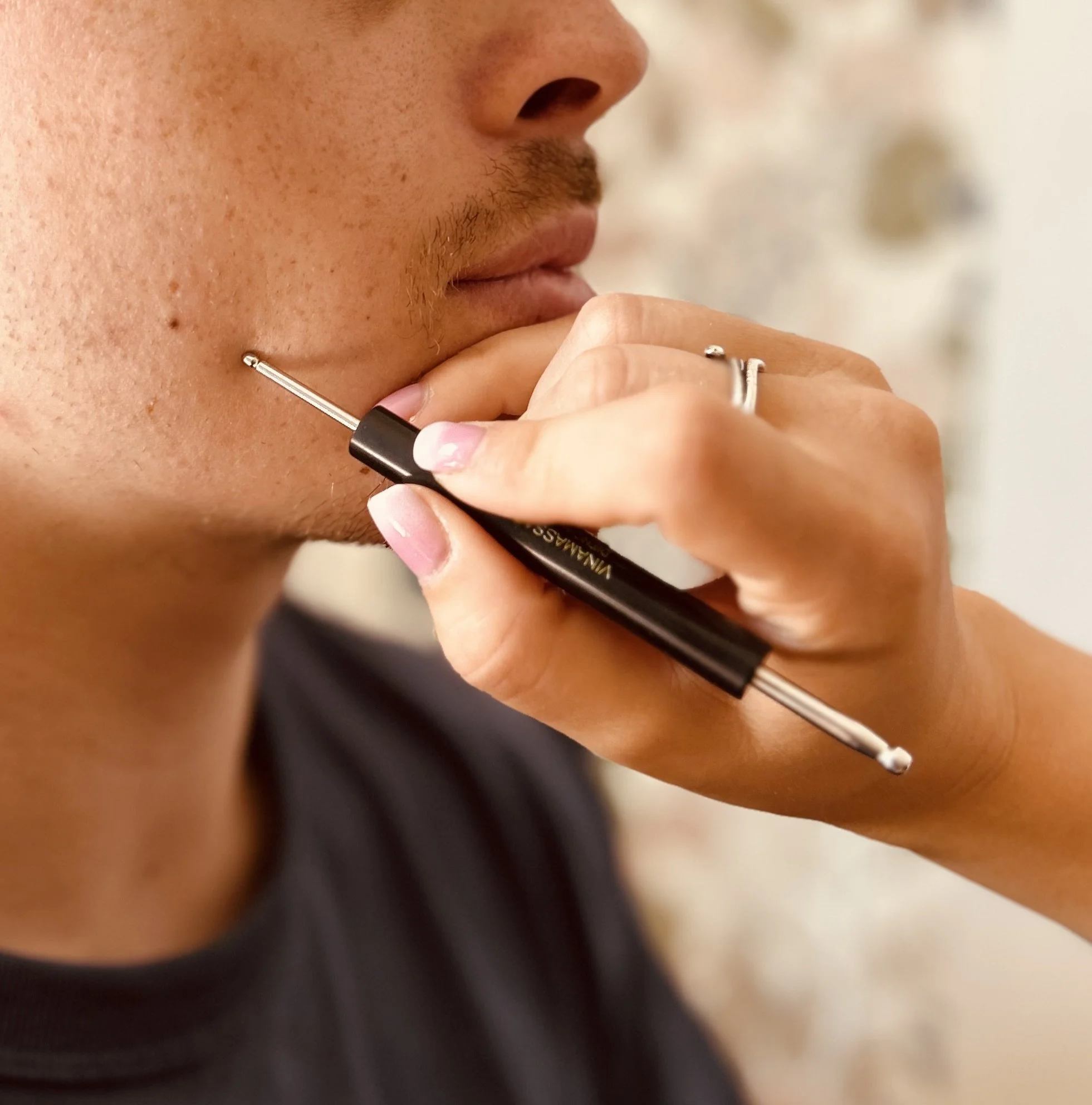 Une personne se rase la moustache avec un rasoir électrique.