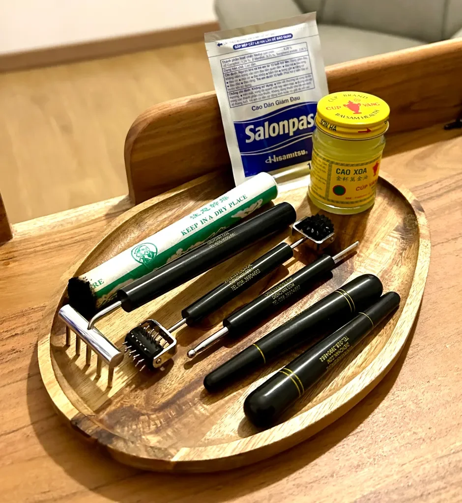 Une planche en bois contenant des outils de rasage, une crème ou savon à barbe, and un pot de baume ou crème pour la peau, sur une surface en bois.