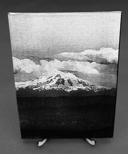 Black and white photo of Mount Fuji with clouds in the sky.
