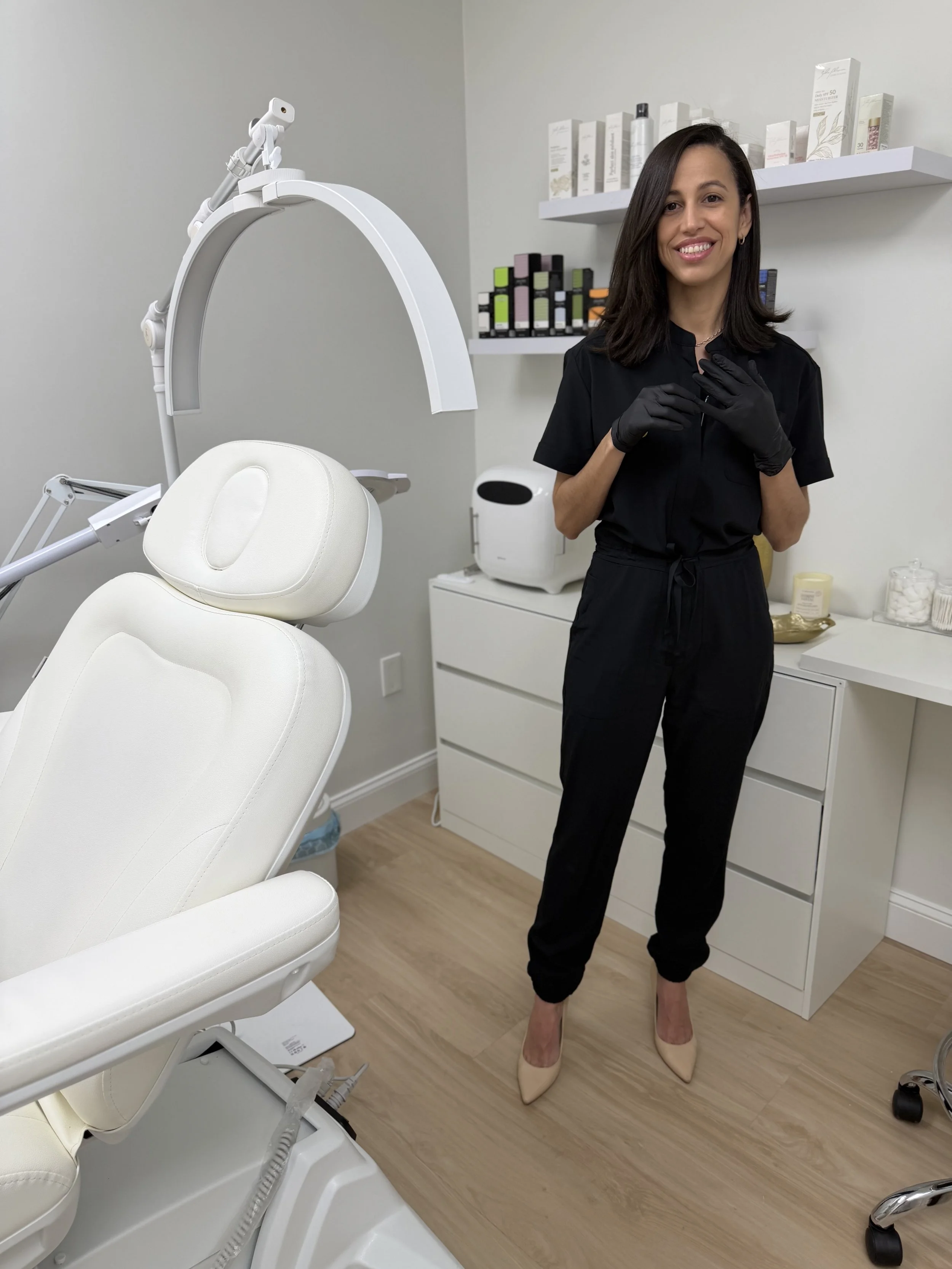 Cassia Zablonski, esthetician and owner of Vitalis Luxe Spa, beside a facial chair in her bright studio welcoming new clients