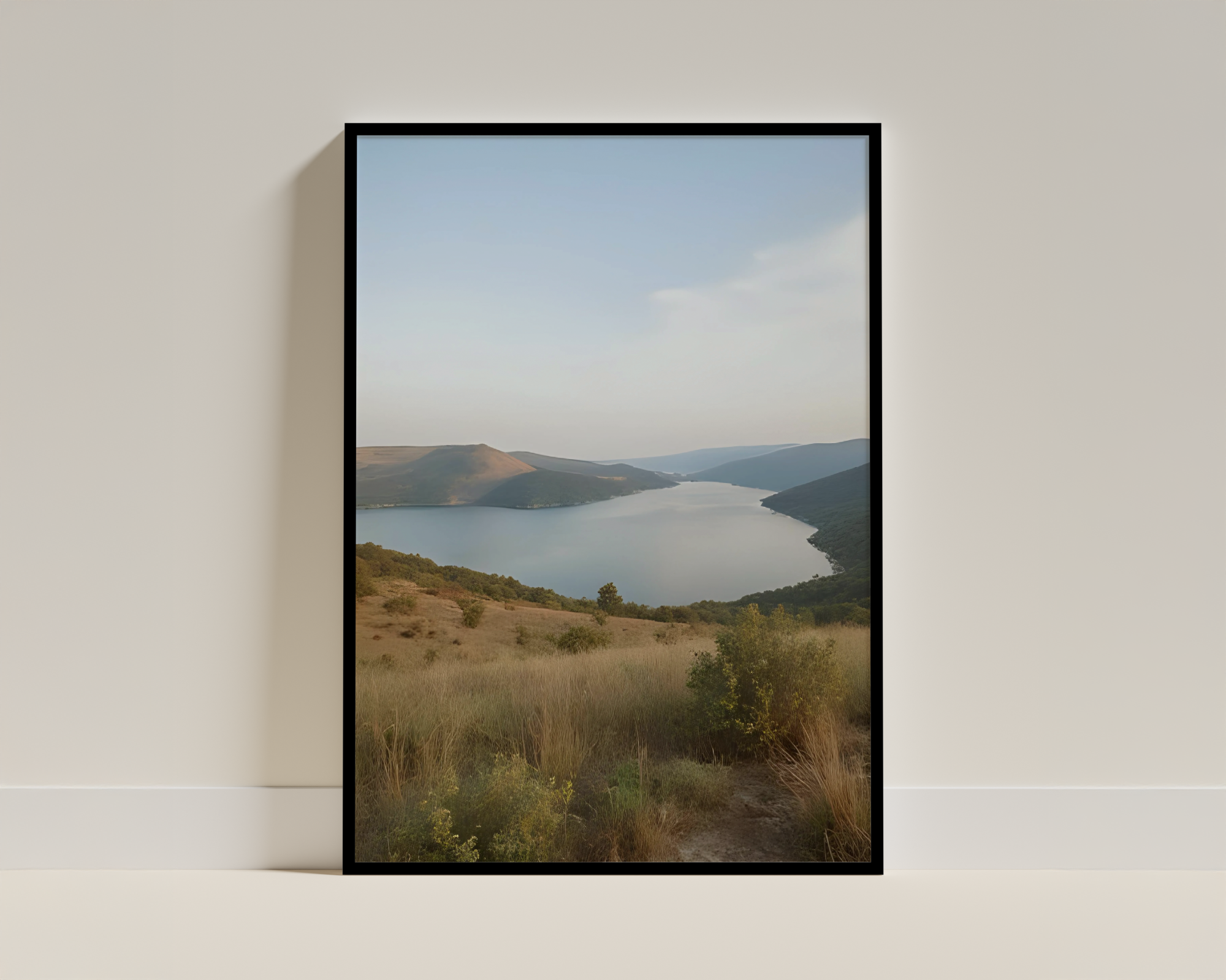 Calm Lake Nestled Among Rolling Hills - Framed Poster