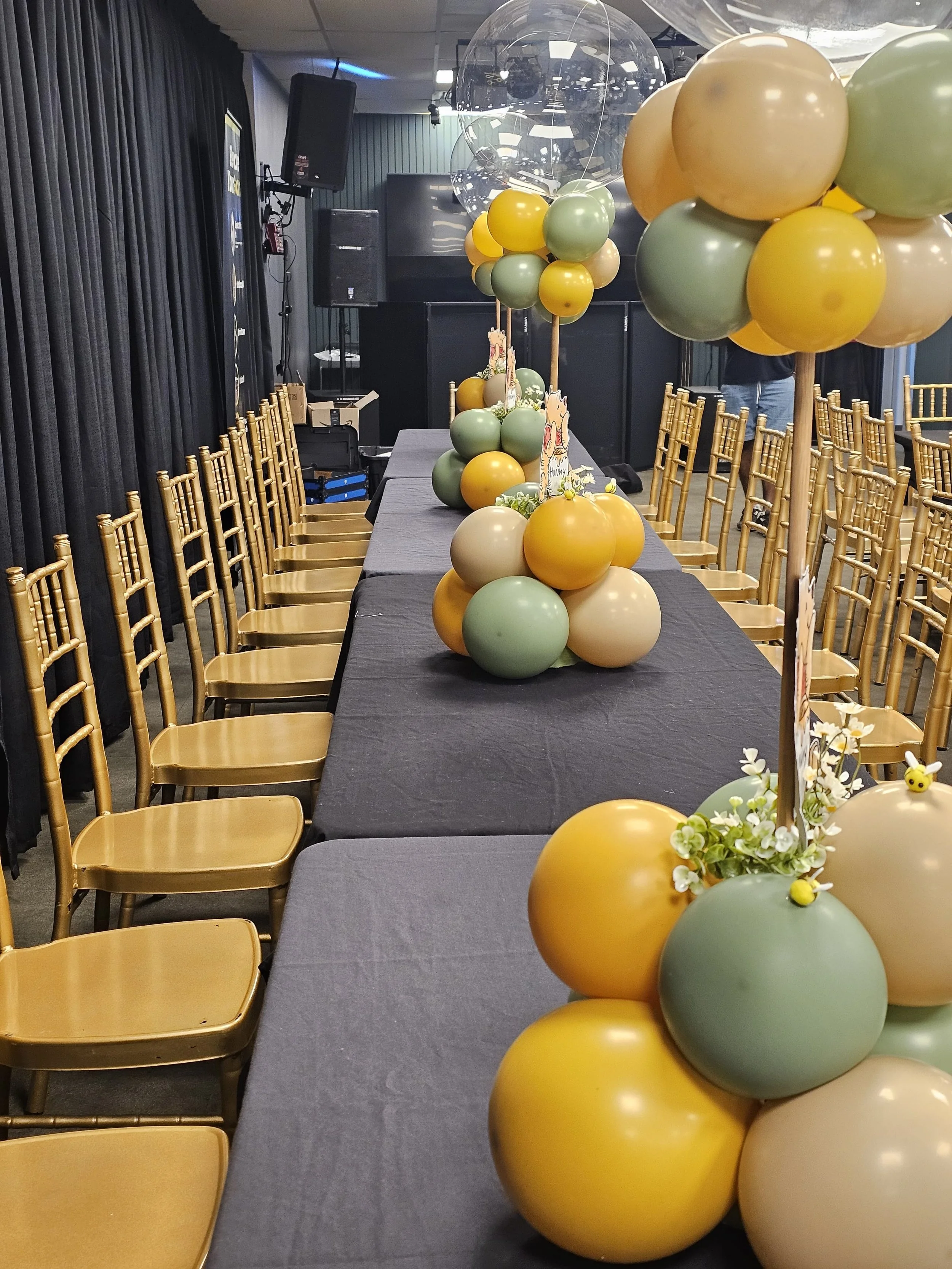 Table decorated with balloons and flowers, set up for a celebration or event.