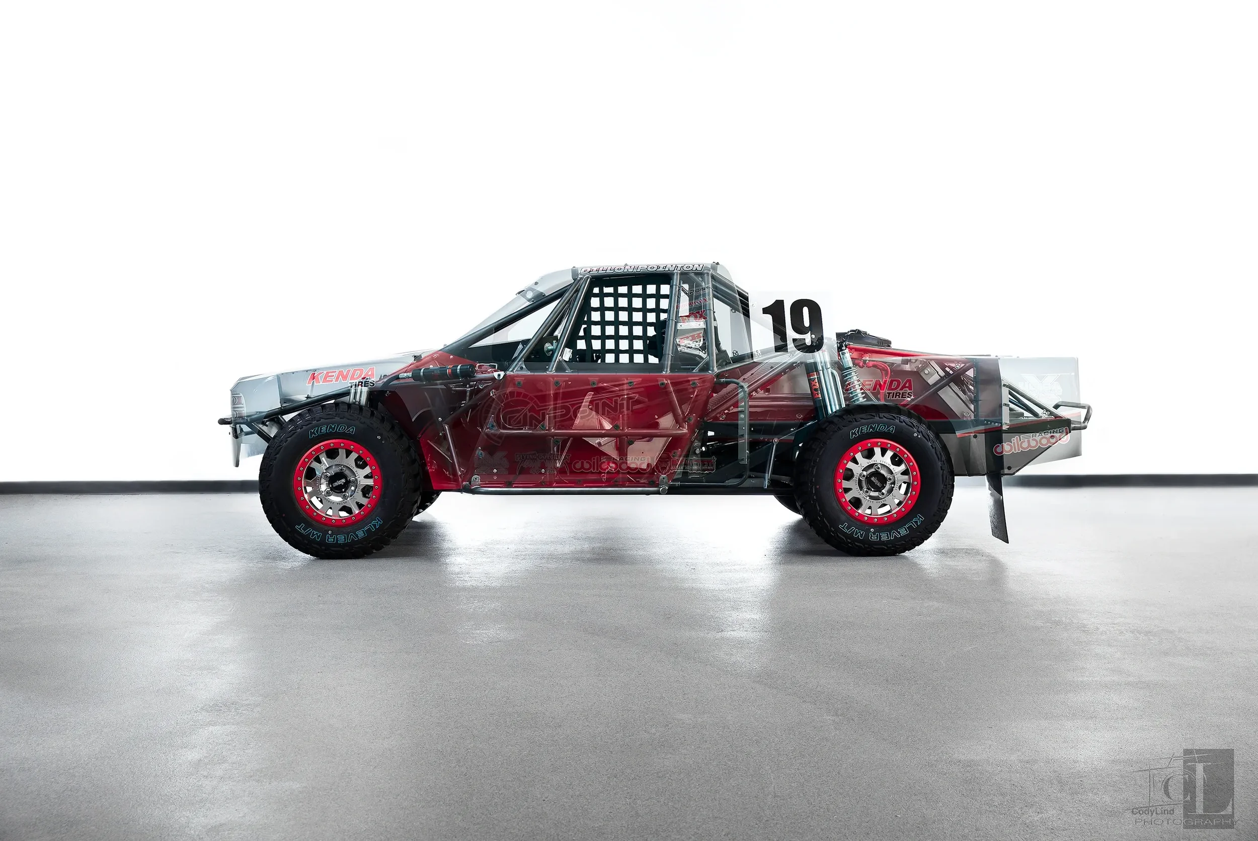 A sleek, transparent race car with red accents and racing tires, displayed against a plain background.