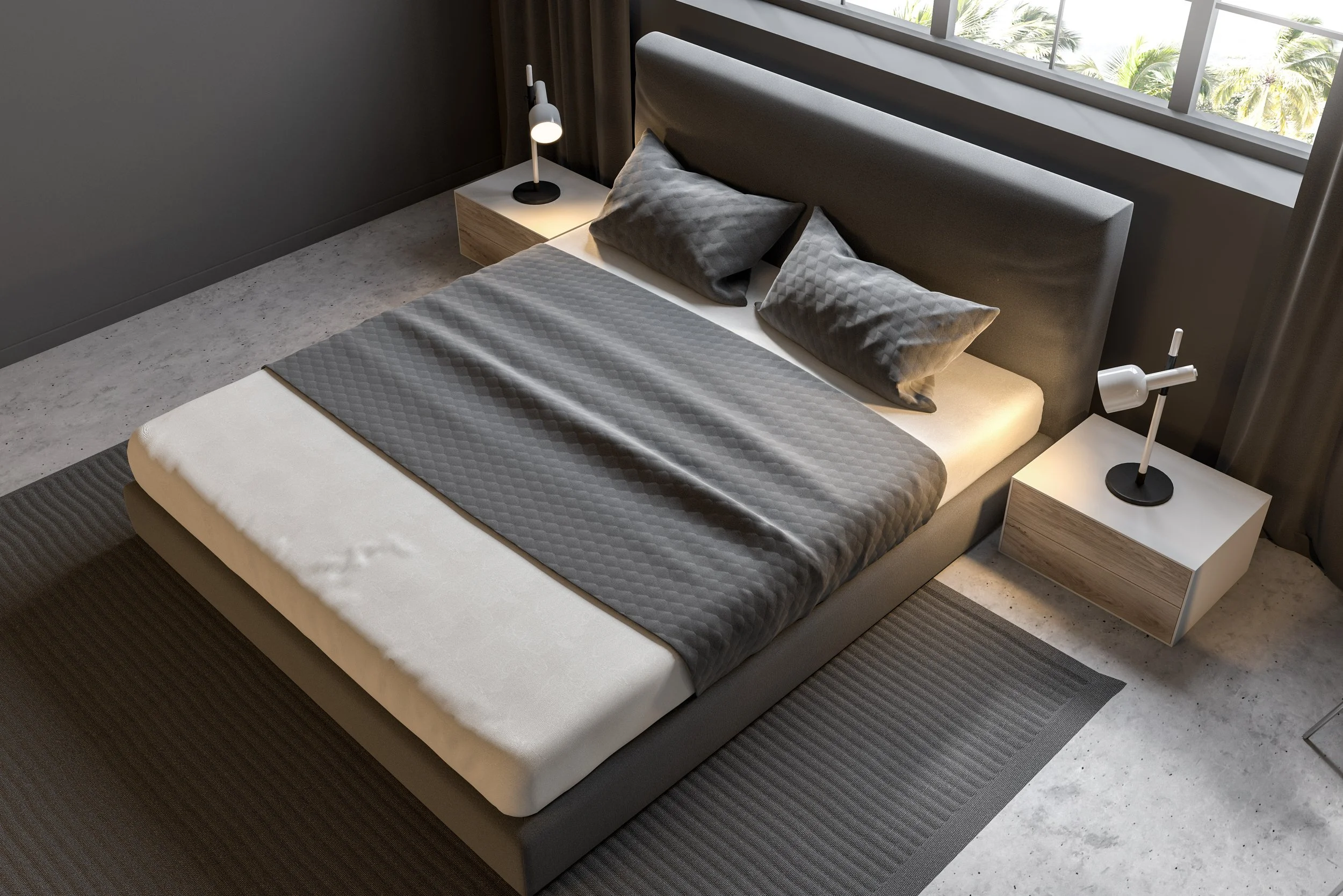 Modern bedroom with a gray upholstered bed, two gray pillows, a gray quilted blanket, and two white nightstands with white lamps. Large window with view of palm trees.