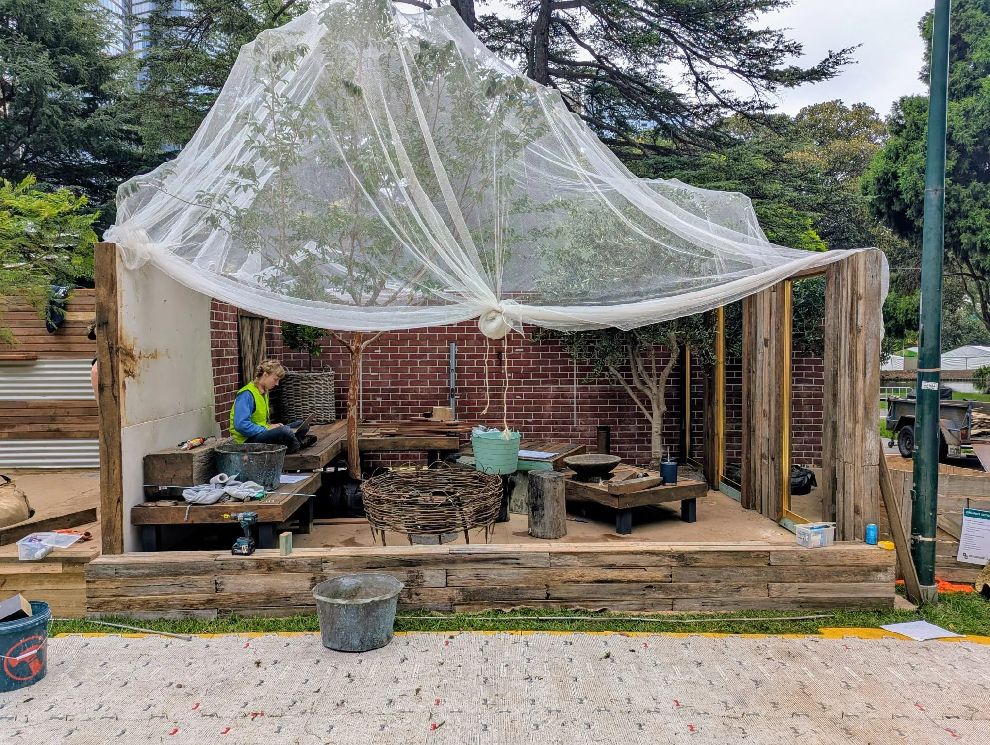 Georgina checking her technical drawings for "A Women's Garden", mid-build at the Melbourne International Flower & Garden Show 2026