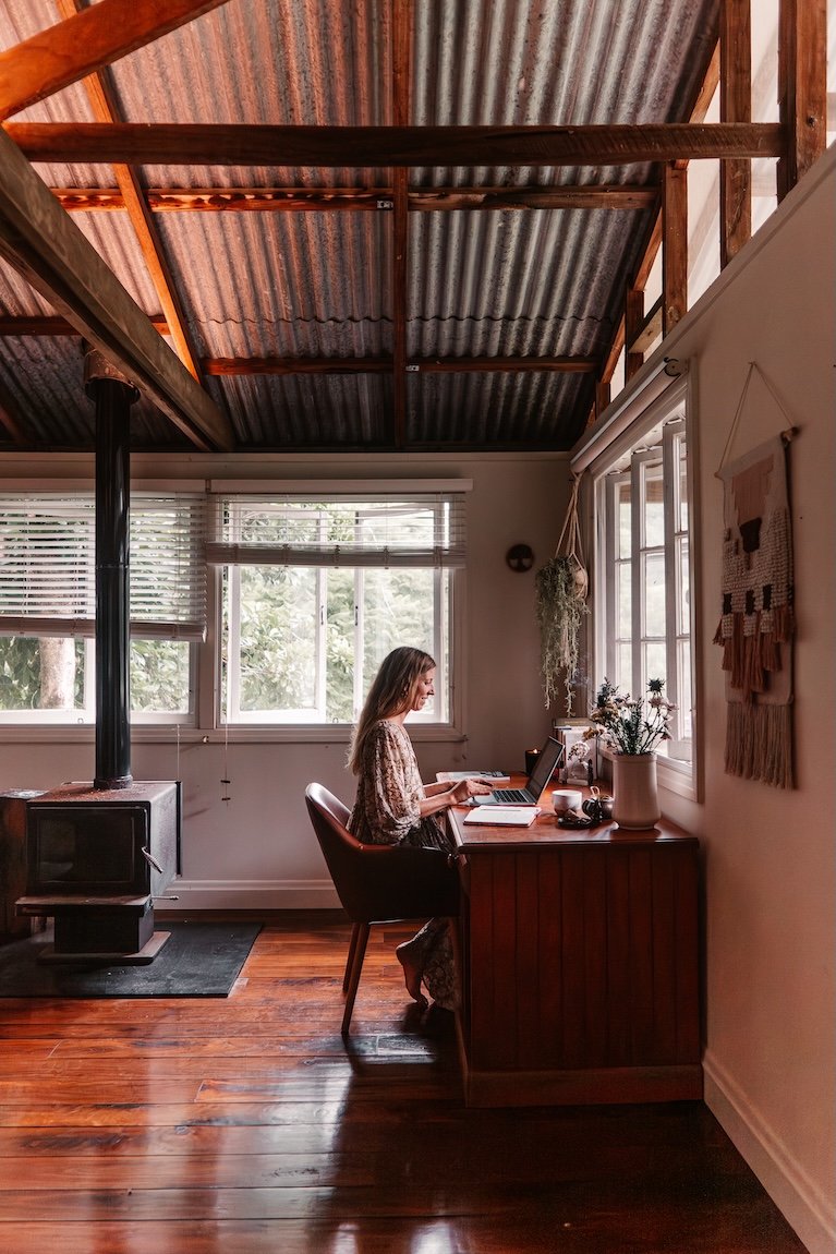 Woman working indoors in a calm environment, representing sustainable wellness and balanced living Gold Coast