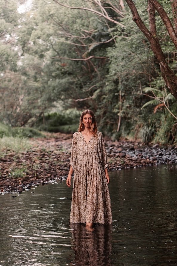 Woman standing in a river in nature, representing holistic healing and Ayurveda in Currumbin Valley on the Gold Coast