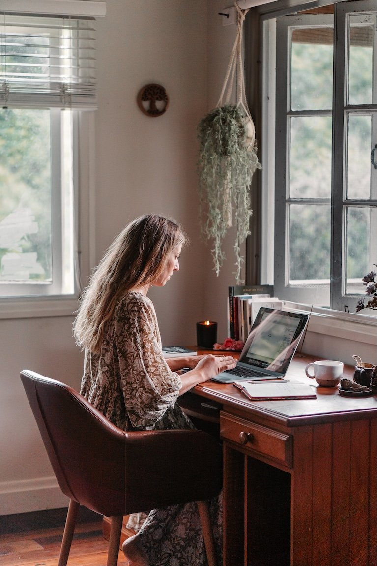 Woman working from home in a calm space, representing balanced lifestyle and holistic wellbeing in Currumbin Valley Gold Coast