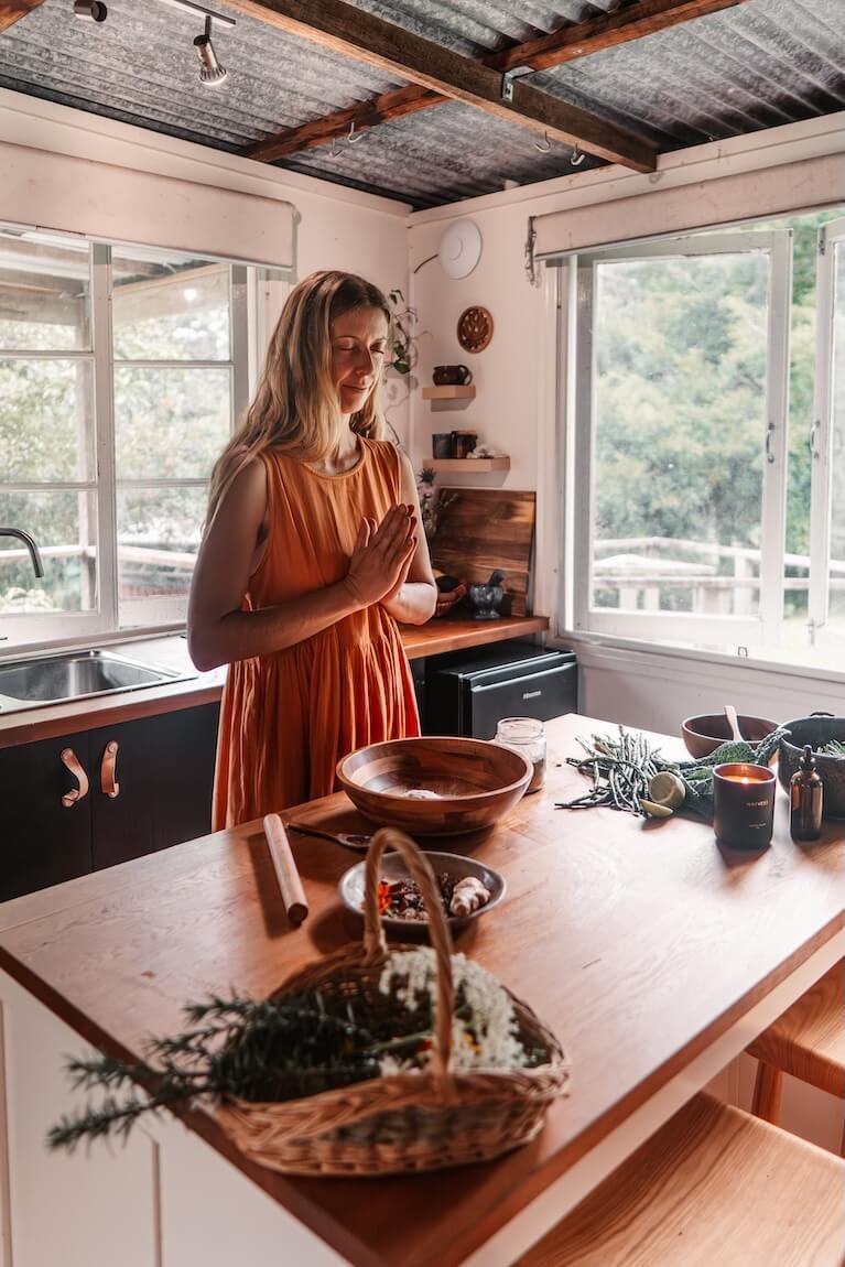 Woman practising mindful ritual in kitchen, reflecting Ayurvedic daily routines and holistic living Gold Coast