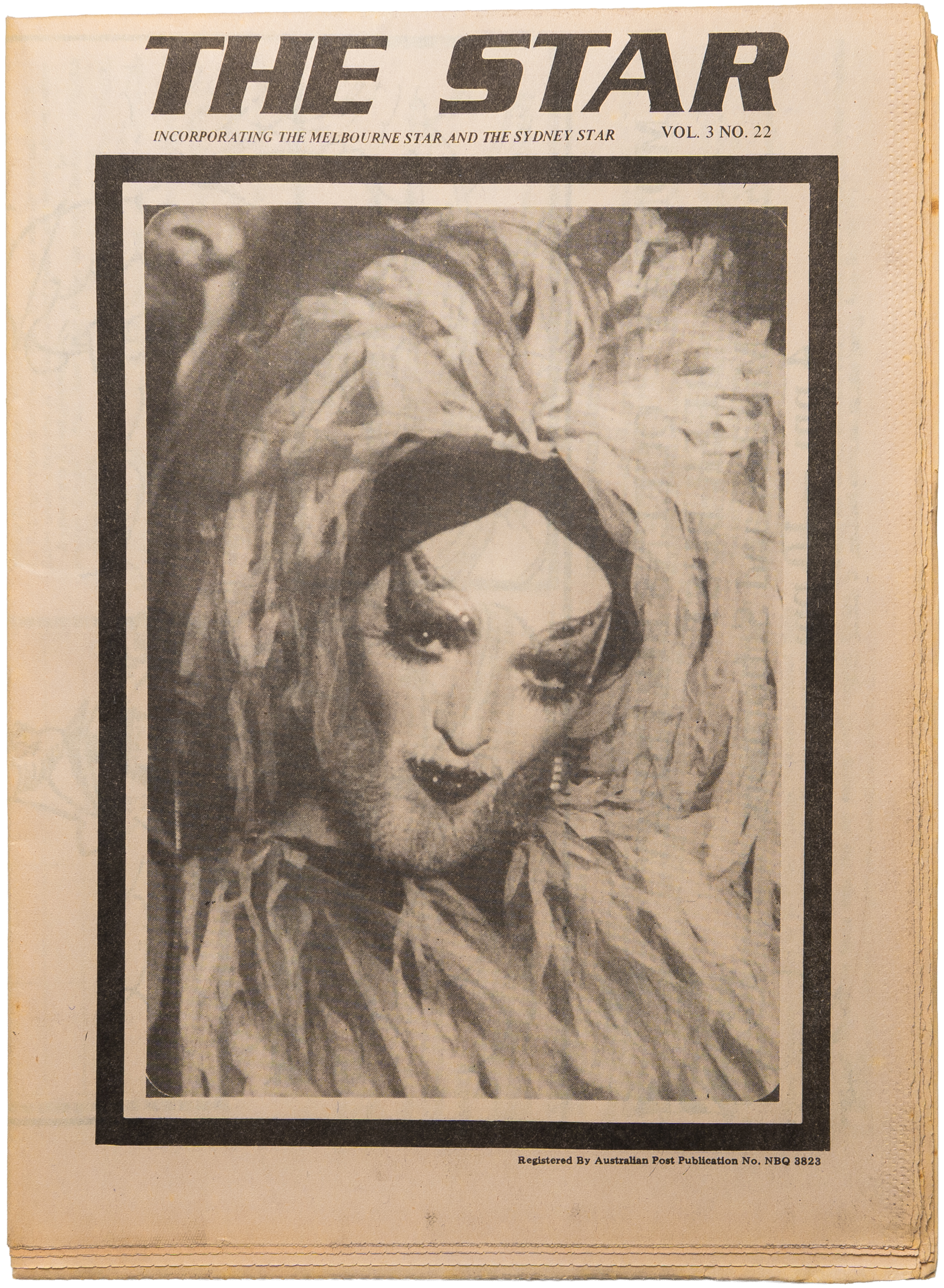 A vintage newspaper cover titled 'The Star' featuring a close-up black and white painting or photograph of a woman with long, curly hair, bold makeup, and red lipstick, wearing a peacock feather headpiece.