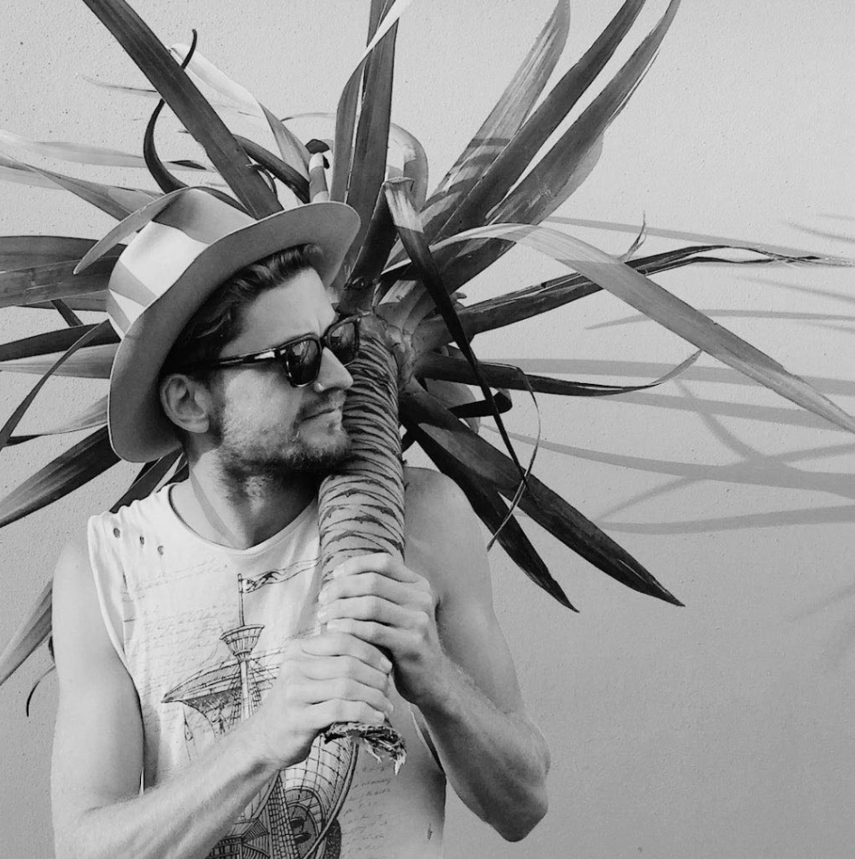Adam Powell holding a plant for a photography session interview in Few & Far