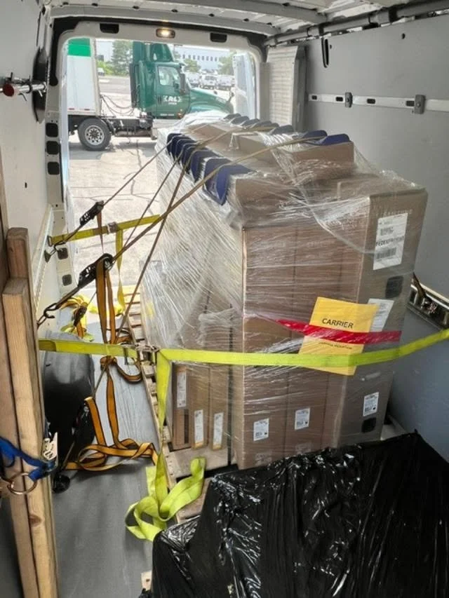 Sprinter van loaded with palletized commercial freight secured with straps for expedited nationwide transportation.