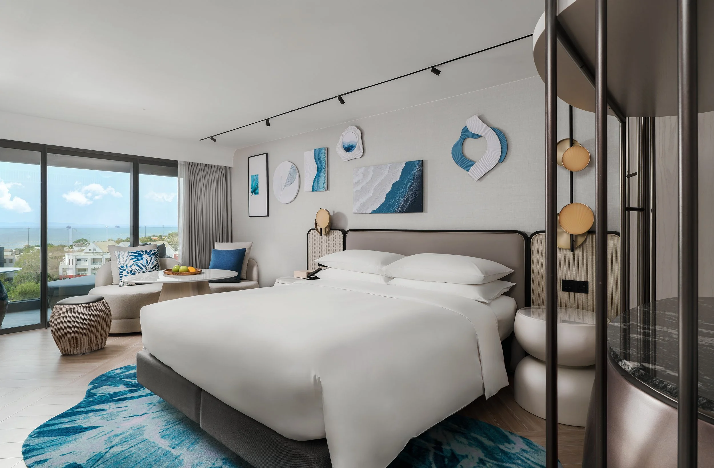 Modern resort room with premium amenities and a large window with an ocean view in Southeast Asia