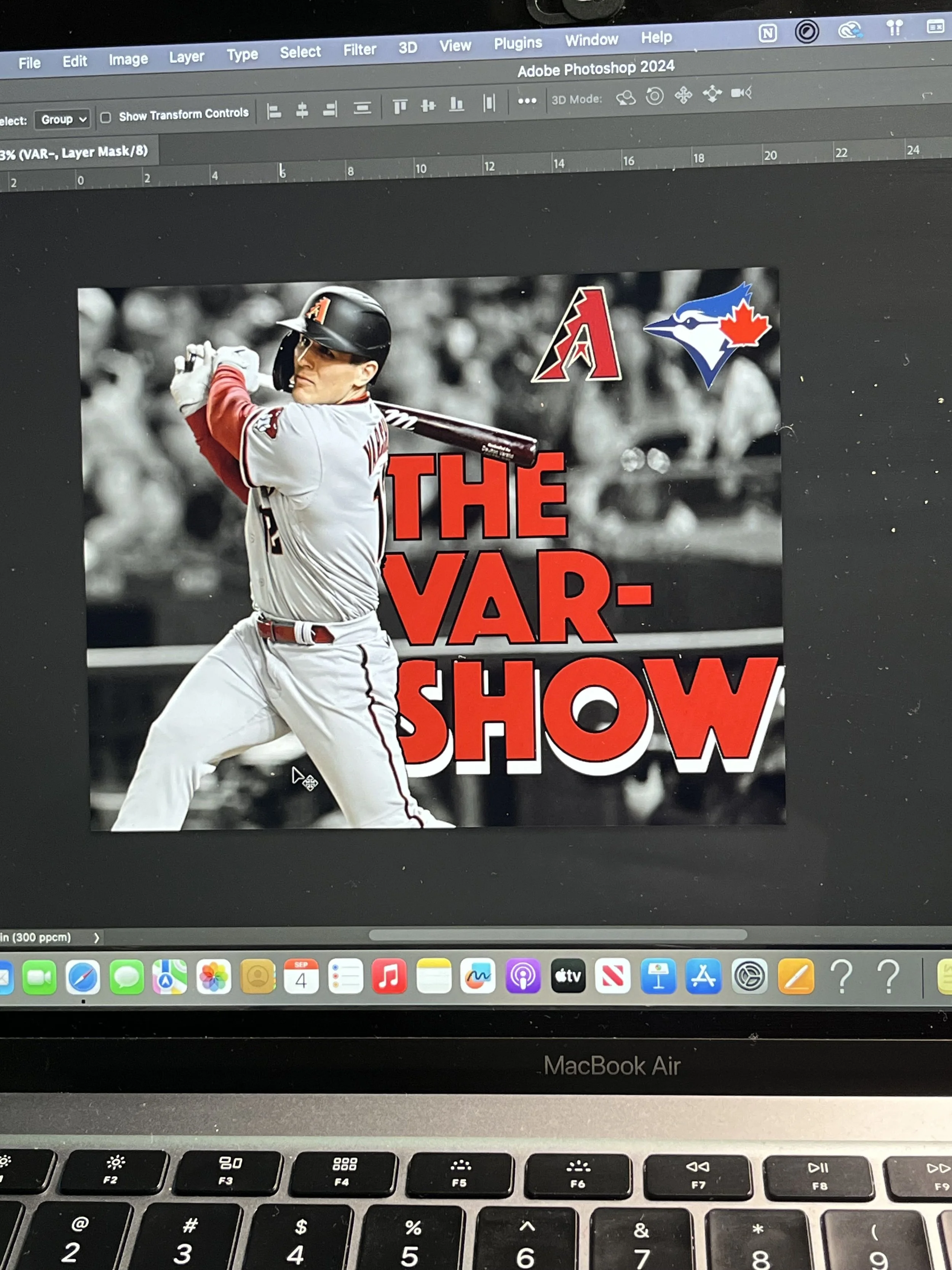 A baseball player in a batting stance, wearing a gray uniform and black helmet, with a blurred crowd in the background. Overlaid on the image is text that reads 'THE VAR SHOW' in large red letters. There are also two team logos at the top right, one red with a stylized 'A' and the other blue and white with a maple leaf, representing the Toronto Blue Jays and Arizona Diamondbacks.