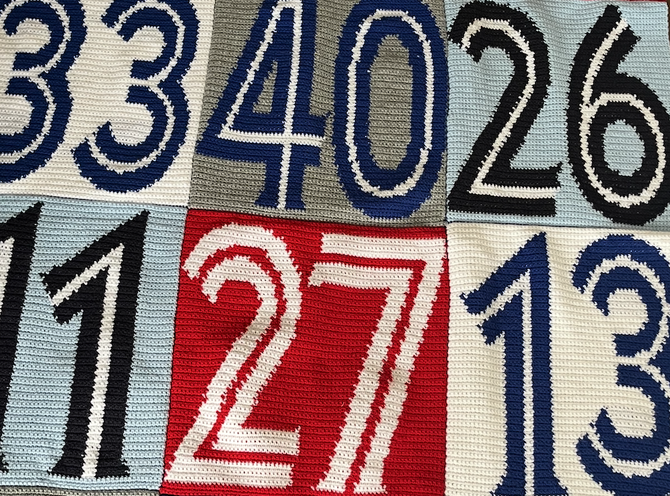 Close-up of a fabric patchwork with large numbers stitched in different colors and styles.